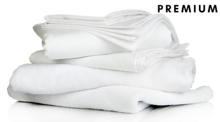Stack of premium white bedding items including a duvet, pillow, pillowcase, duvet cover, and fitted sheet, showcasing soft fabric and a clean, minimalist design.