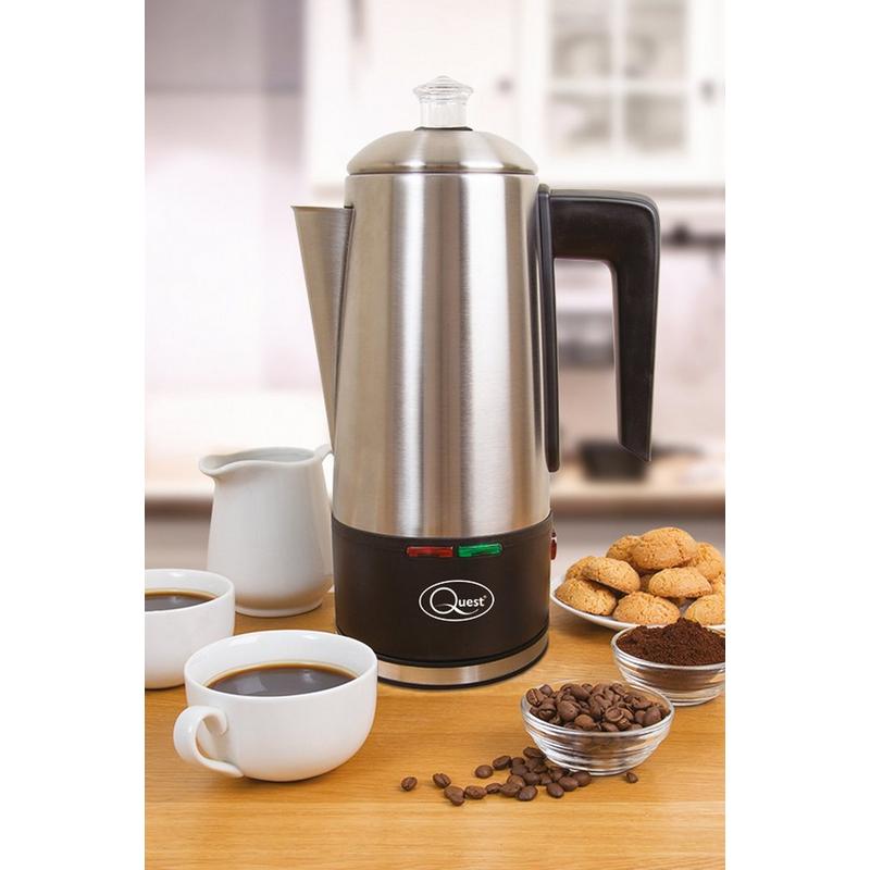 Stainless steel Quest 1.8L electric coffee percolator with a black base, featuring a spout, handle, and indicator lights, surrounded by coffee cups, beans, and cookies.