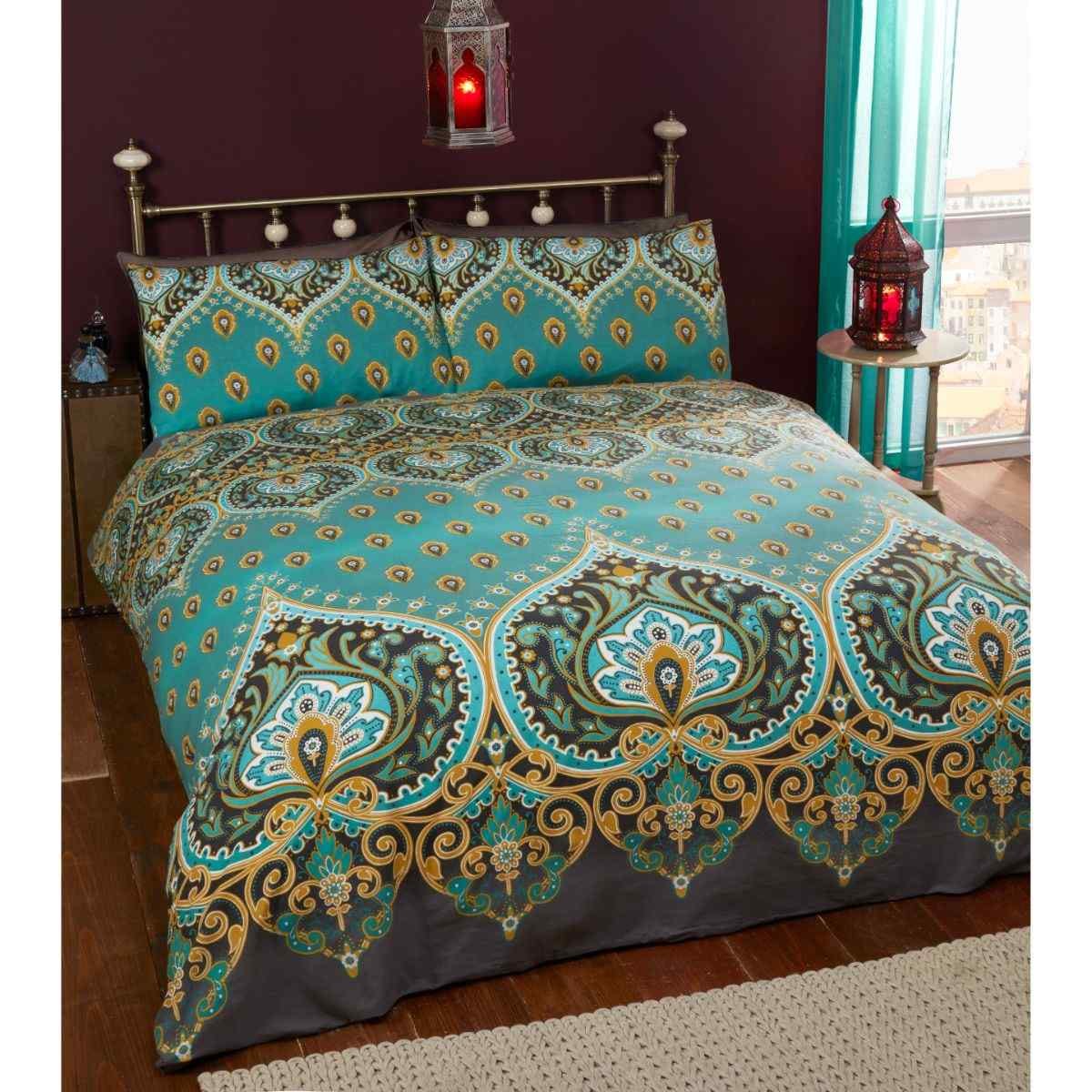 Emerald teal duvet cover set featuring intricate paisley patterns in gold and blue, accompanied by two matching pillowcases, set against a dark background.