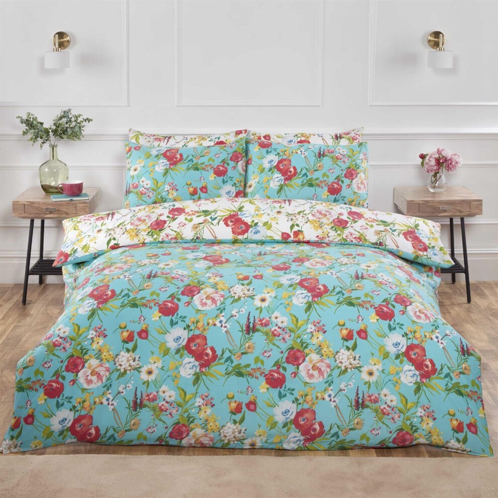 Reversible king duvet cover set featuring a vibrant floral pattern in duck egg blue, complemented by matching pillowcases, set against a stylish bedroom backdrop.