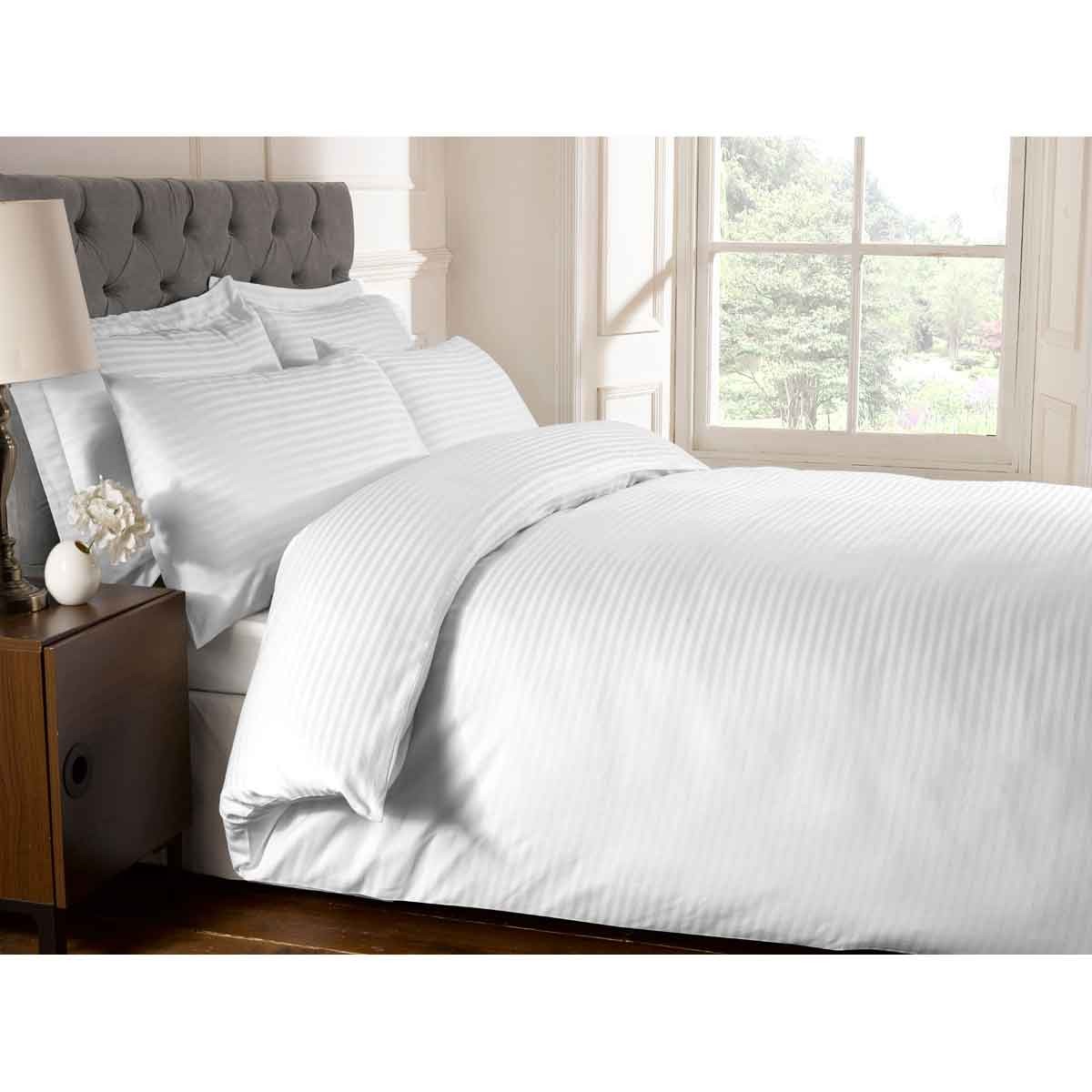 White quilt cover set with a 250 thread count, featuring subtle striped texture, paired with matching pillowcases on a neatly made double bed beside a nightstand.