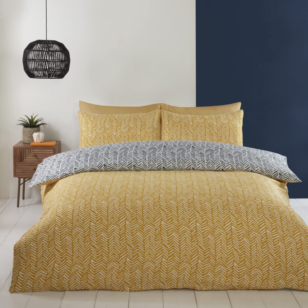 Double duvet set featuring a vibrant ochre yellow with a herringbone pattern, complemented by a reversible grey and white design, set against a minimalist room backdrop.
