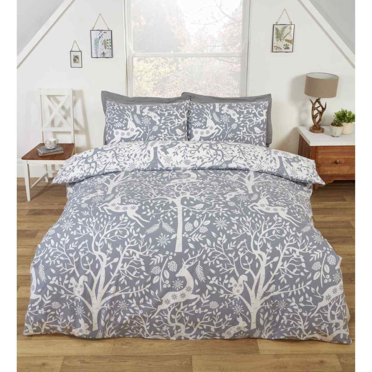Reversible king size duvet cover set in festive grey, featuring intricate white tree and bird patterns, complemented by matching pillowcases, ideal for winter decor.