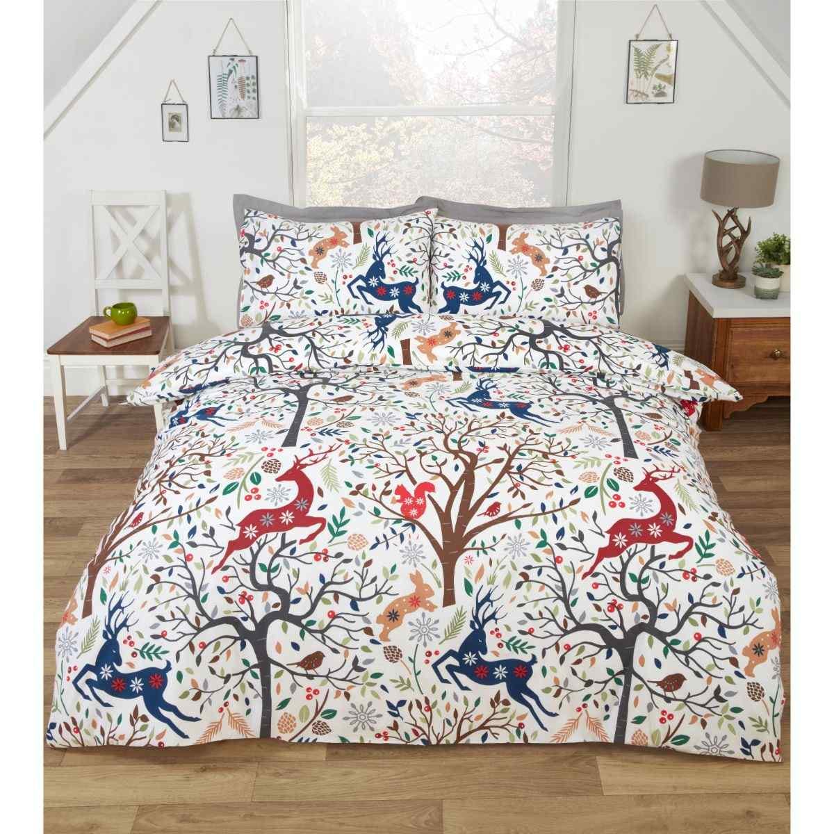 Tatton Multi Duvet Set features a vibrant design with red deer and colorful trees on a white background, complemented by matching pillowcases, suitable for a single bed.