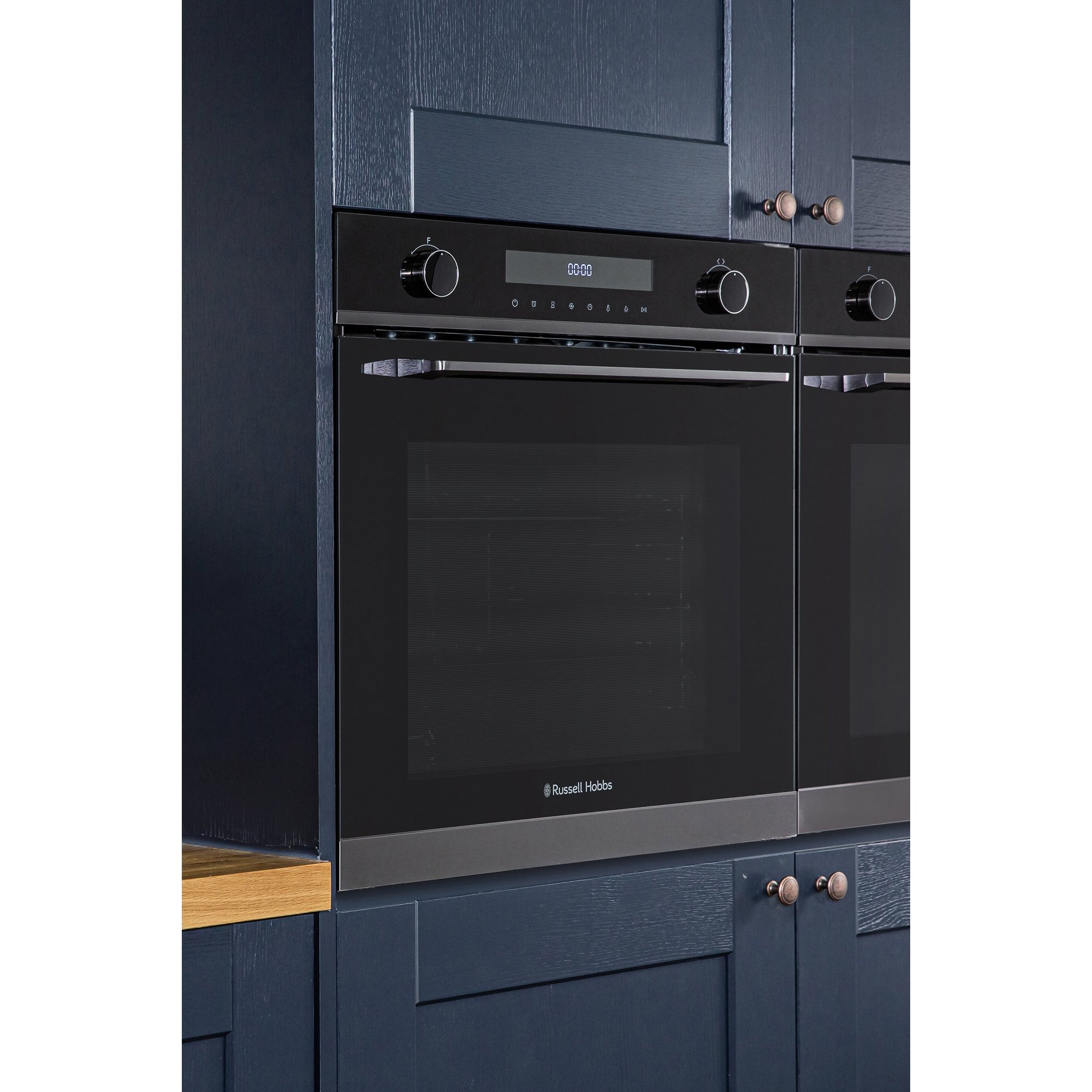Black multi-functional electric oven with a sleek design, featuring a glass door, stainless steel accents, and control knobs, set against dark cabinetry.