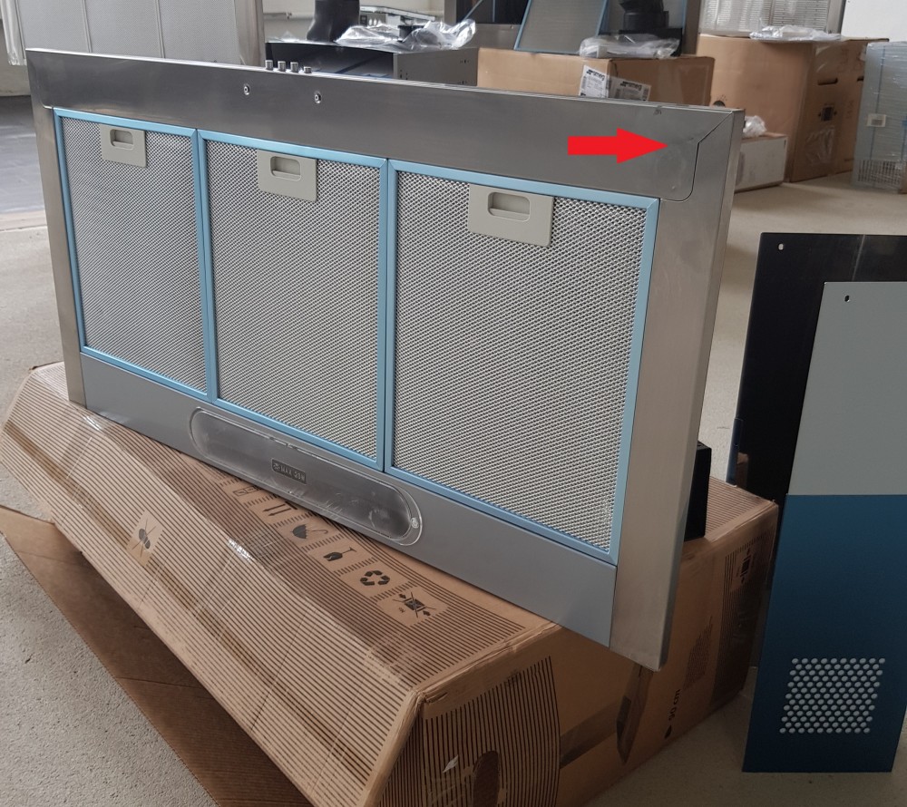 Silver Samsung integrated hood with a sleek design, featuring three mesh filters and a ducted extraction option, placed on a cardboard box in a warehouse setting.