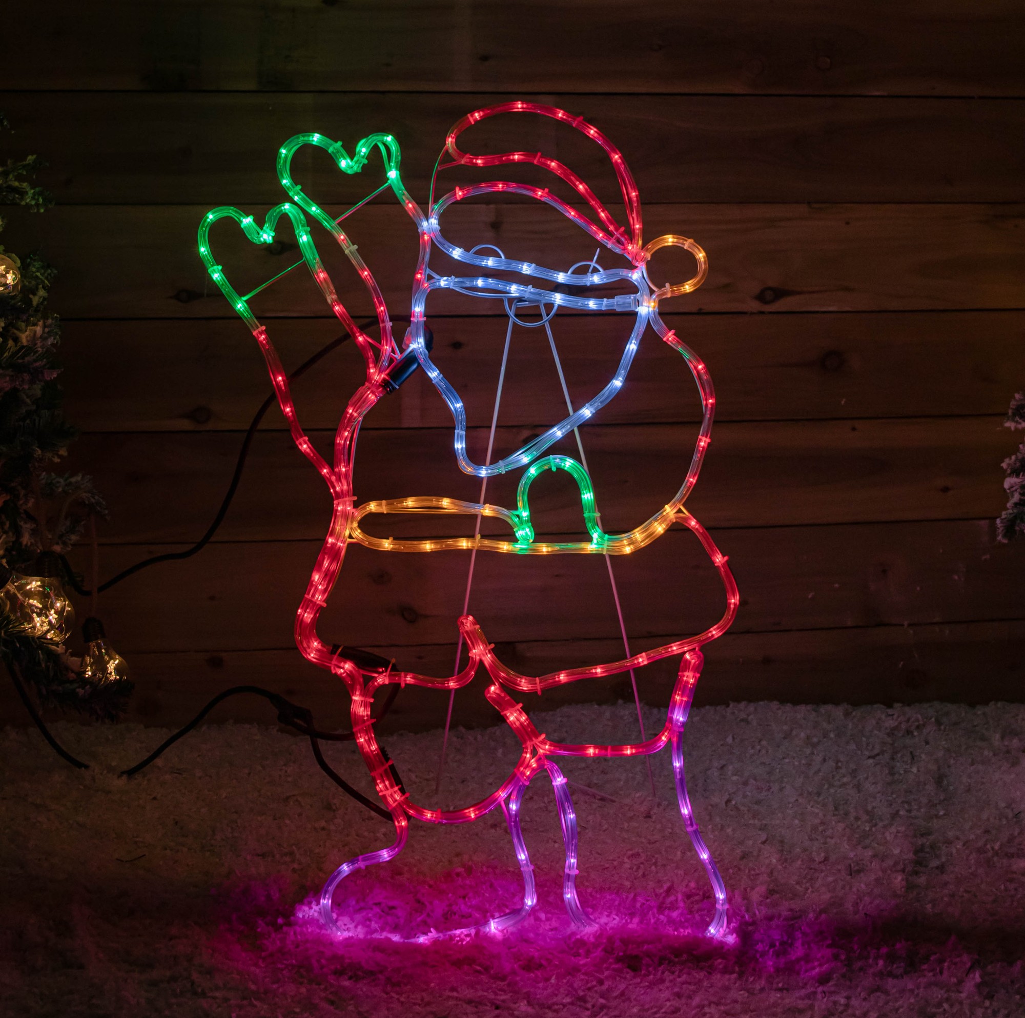 A 92cm standing Santa figure made of flexible rope lights, featuring 192 multi-coloured LEDs in static and flashing modes, with a red hat and gloves, set against a wooden backdrop.