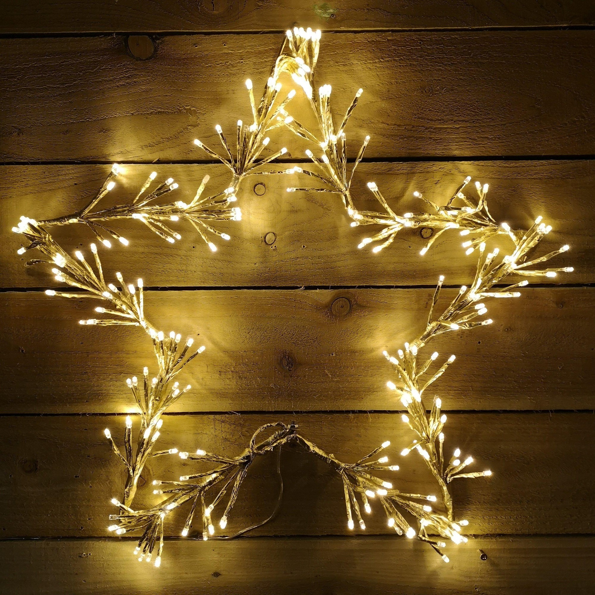 60cm gold star cluster decoration featuring 240 warm white LED lights, crafted from a flexible material, designed to hang on walls or windows.