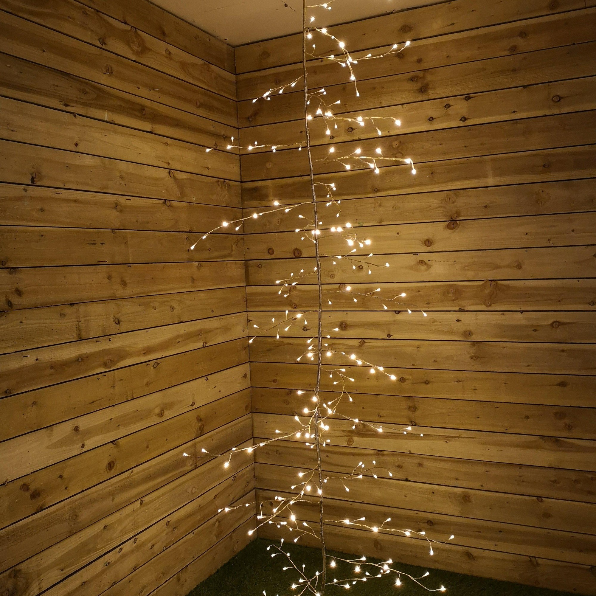 Gold branch garland with 288 warm white LED lights, 3 meters long, featuring delicate branches adorned with glowing lights against a rustic wooden background.