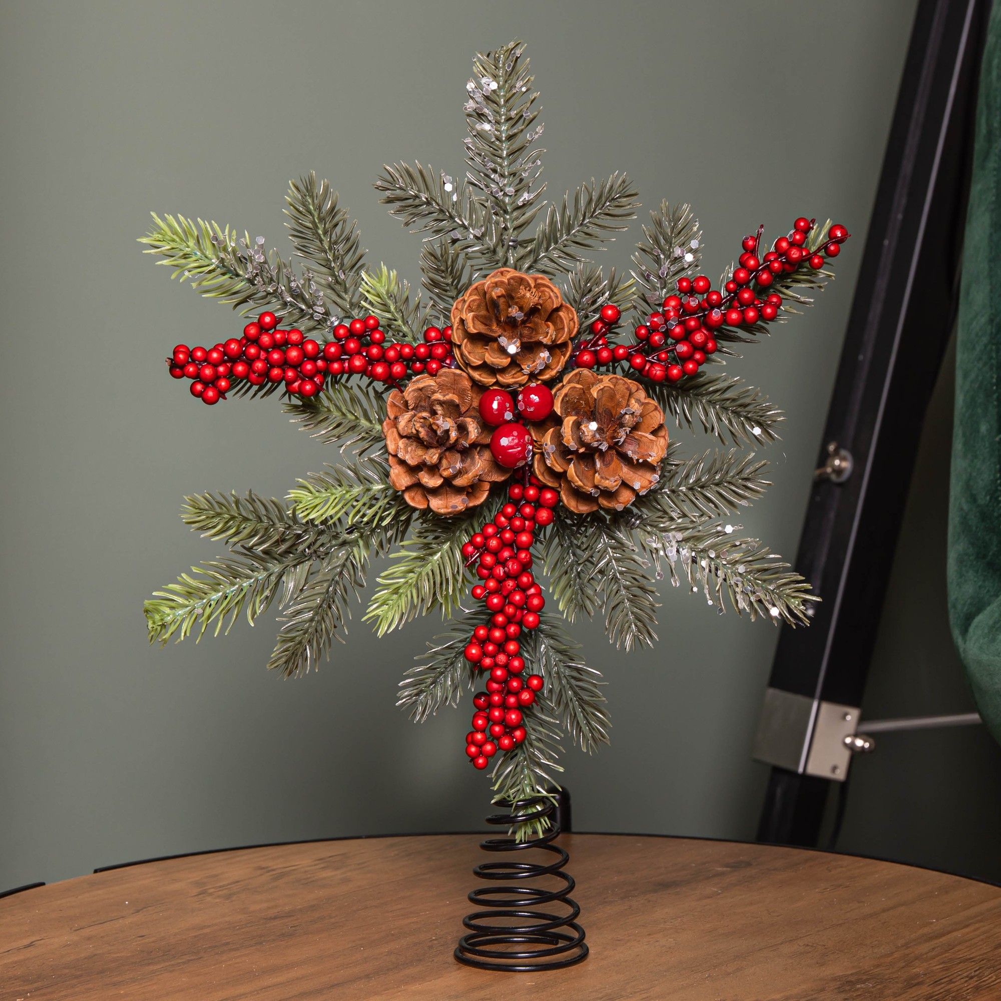 Red Christmas tree topper featuring frosted foliage, pinecones, and clusters of red berries, with a spiral metal base for easy attachment.