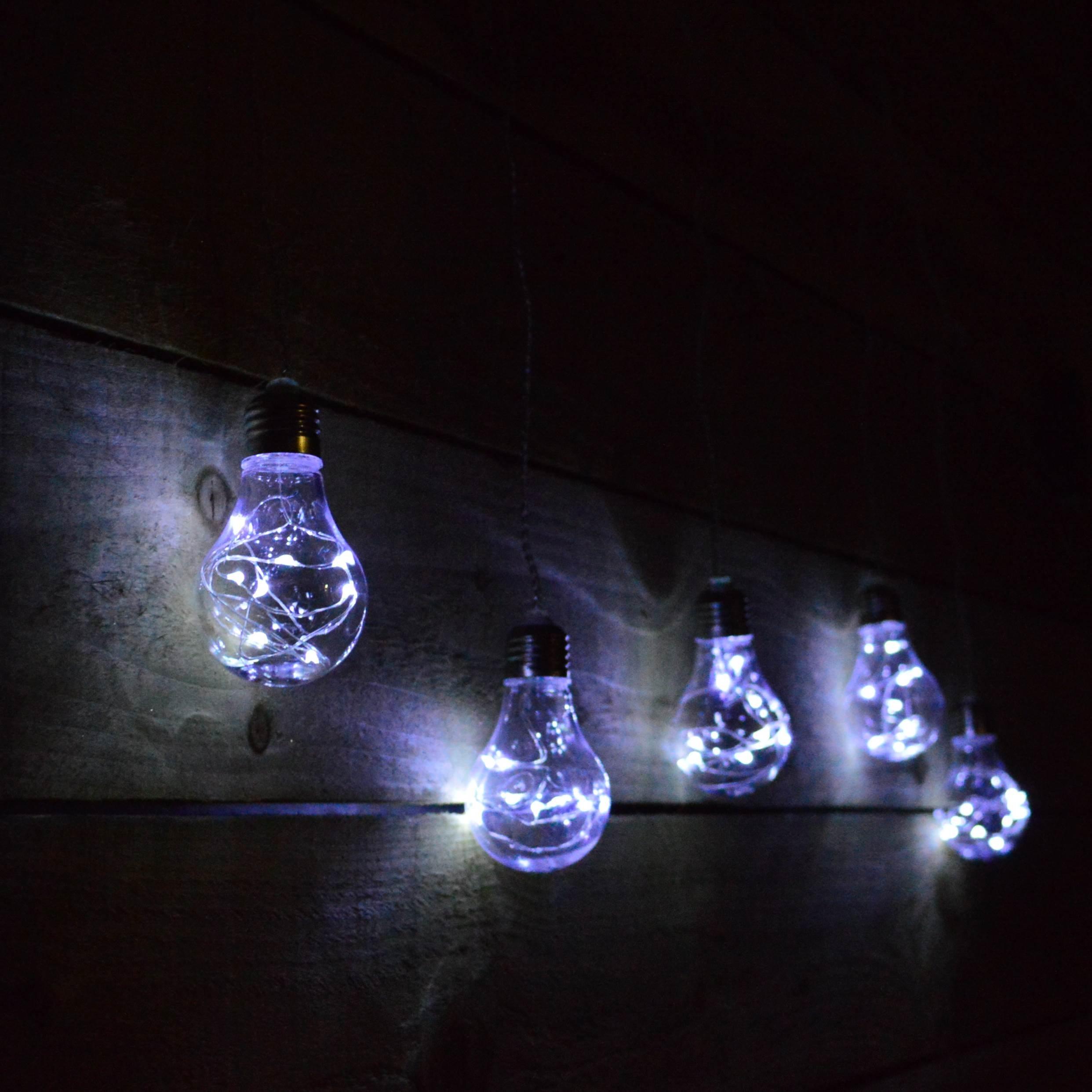 Set of 5 clear glass Edison-style bulbs with cool white pin wire LEDs, featuring a timer, hanging against a dark wooden background.