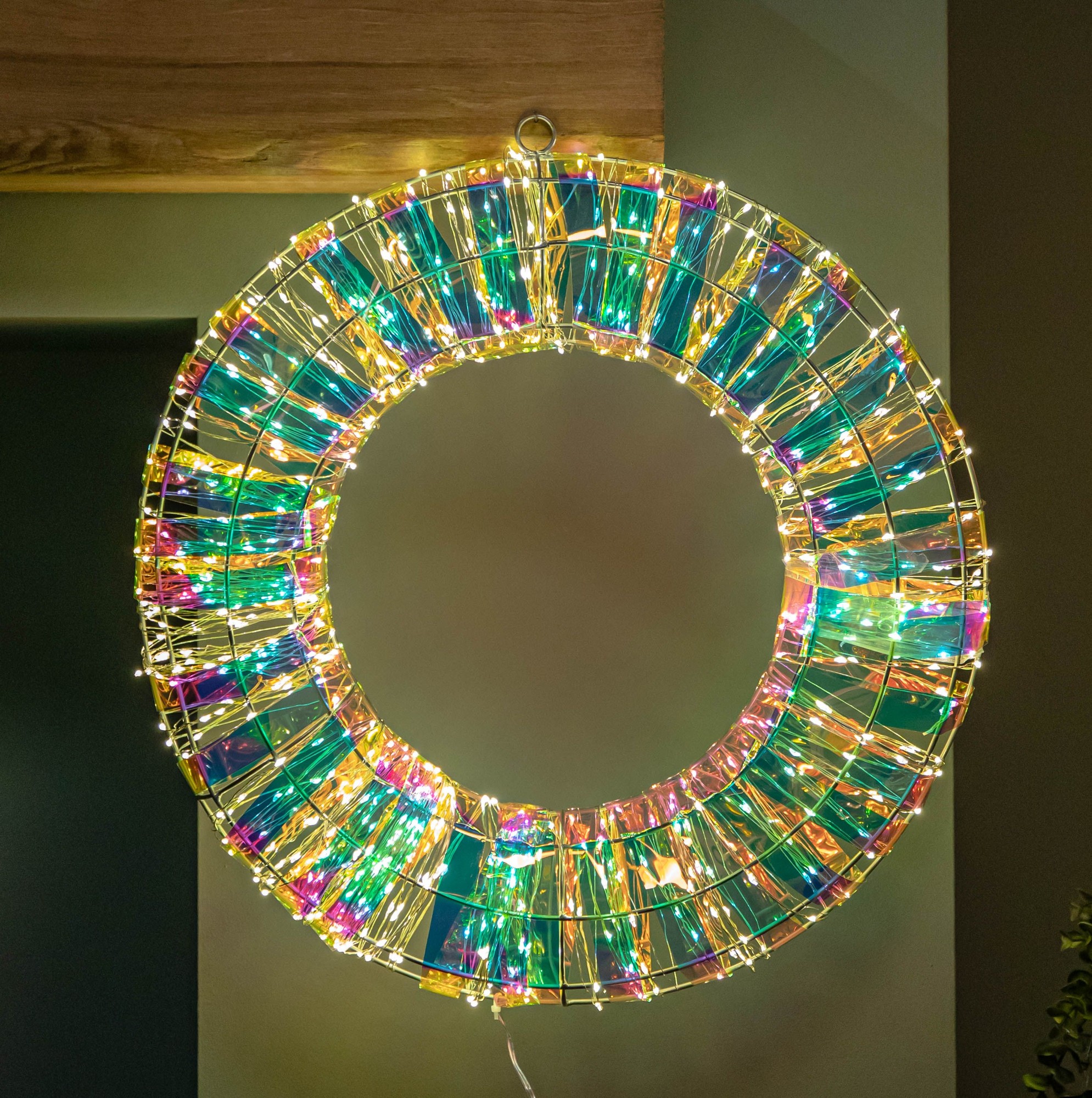 A 45cm iridescent Christmas wreath featuring a mix of green and gold reflective materials, illuminated by 600 warm white LEDs, creating a vibrant, festive glow.