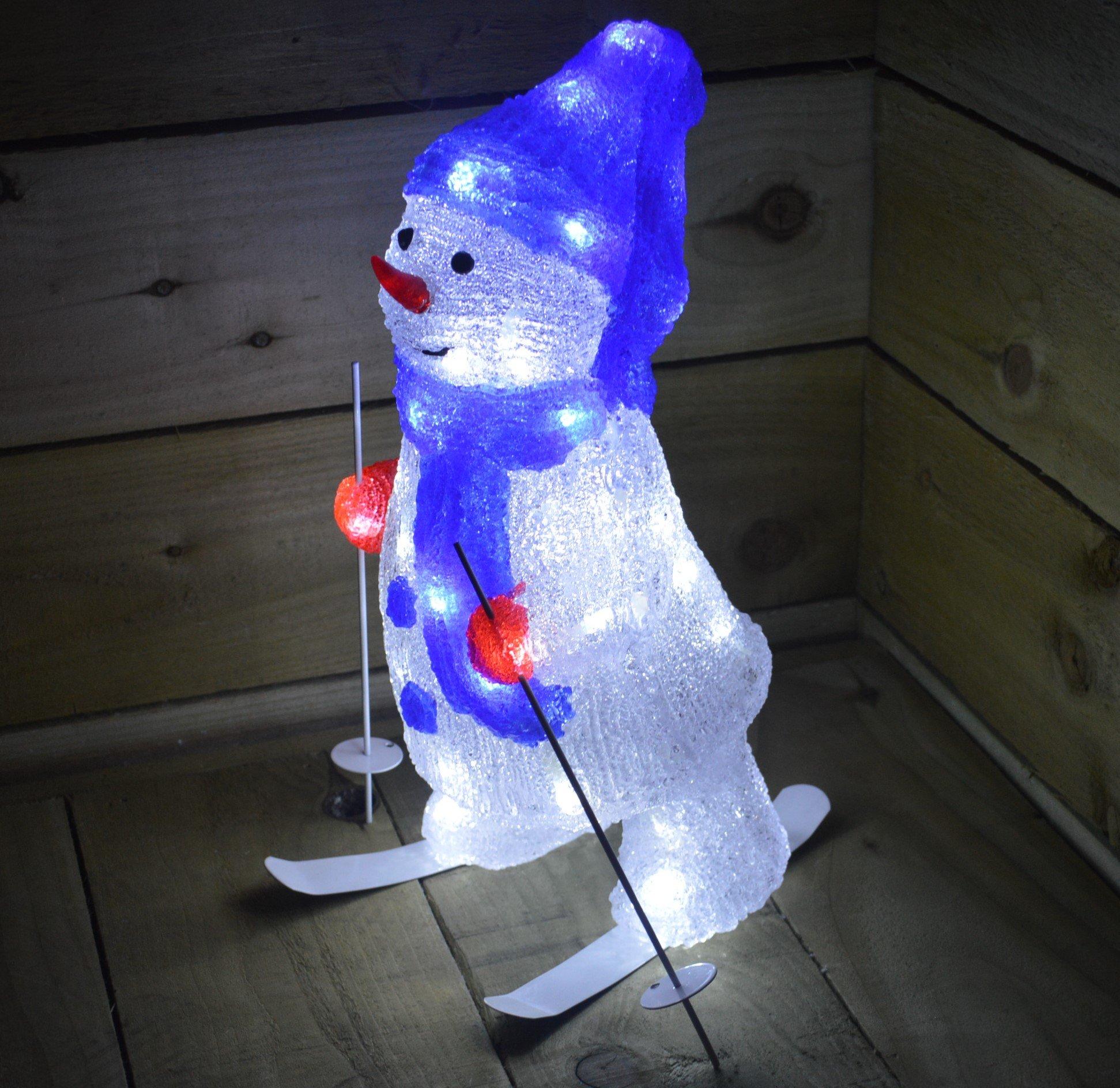40cm tall snowman decoration with a blue hat and scarf, red gloves, and 48 ice white LEDs, standing on skis against a wooden backdrop.