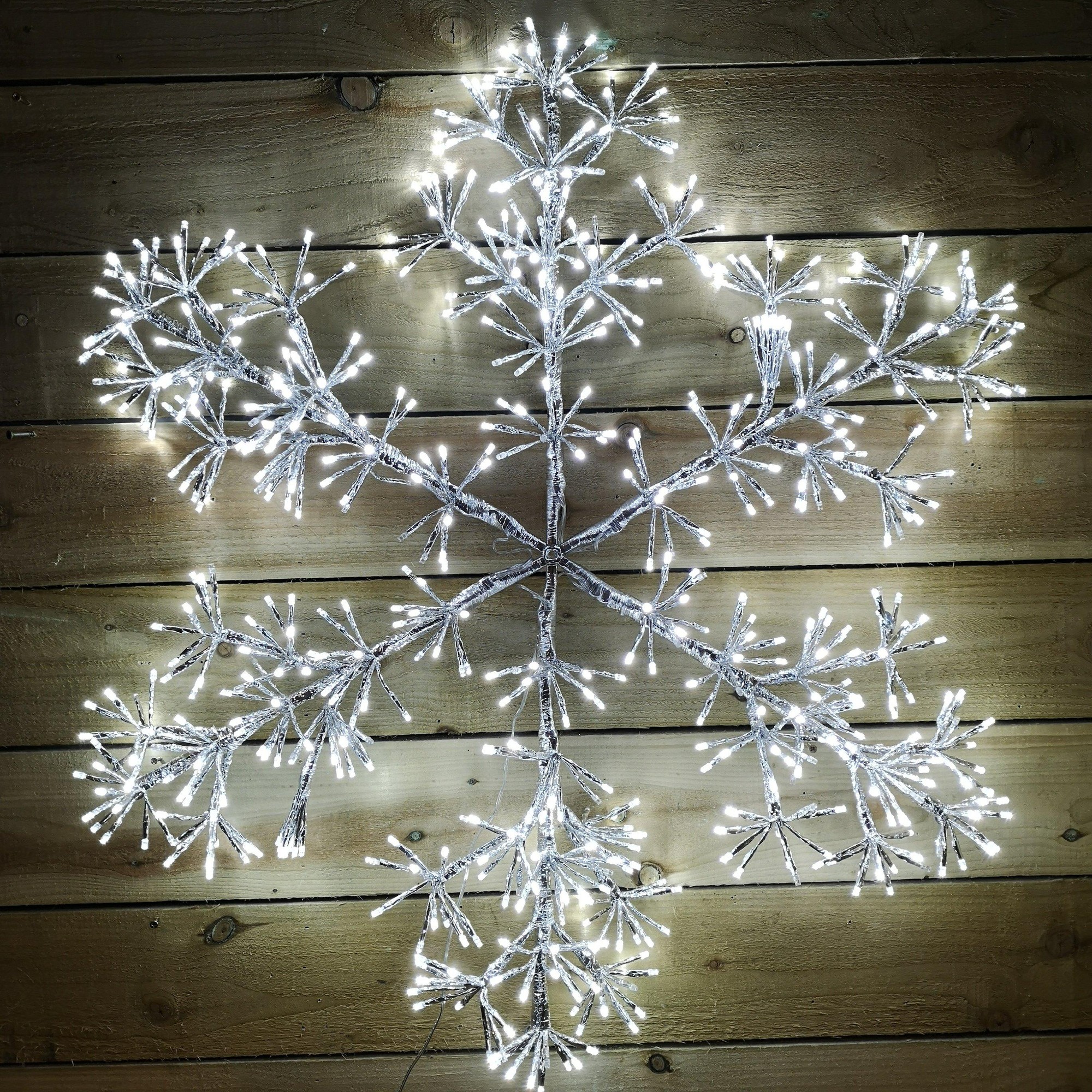 90cm silver starburst snowflake decoration with 660 white LEDs, featuring a detailed, intricate design and a shimmering finish, ideal for festive wall or window displays.