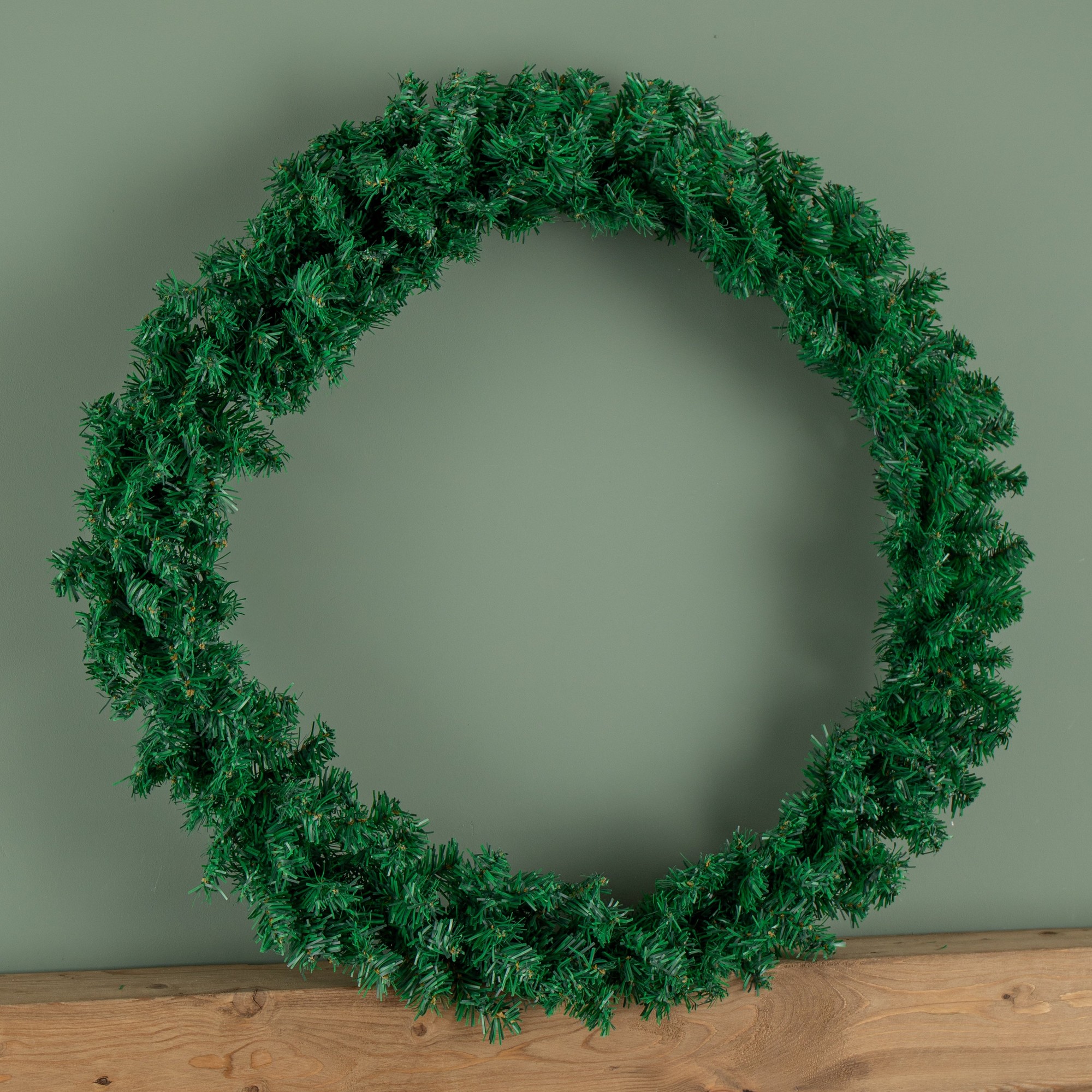 90cm plain green Christmas wreath made of artificial material, featuring 240 tips for a full, lush appearance, displayed against a muted green background.