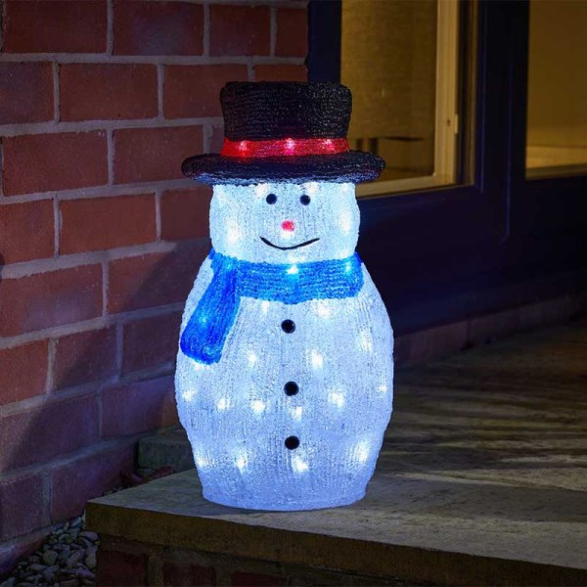 Battery-operated LED snowman decoration, 44cm tall, made of white acrylic with a black top hat, blue scarf, red buttons, and illuminated with white lights.