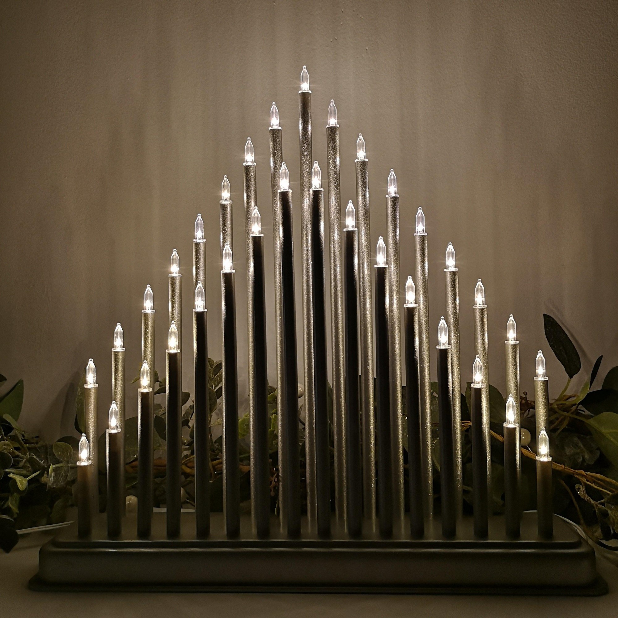 Premier 34cm silver candlebridge featuring 33 warm white LED lights, with tall, slender candle-like structures arranged in a triangular design on a sturdy base.