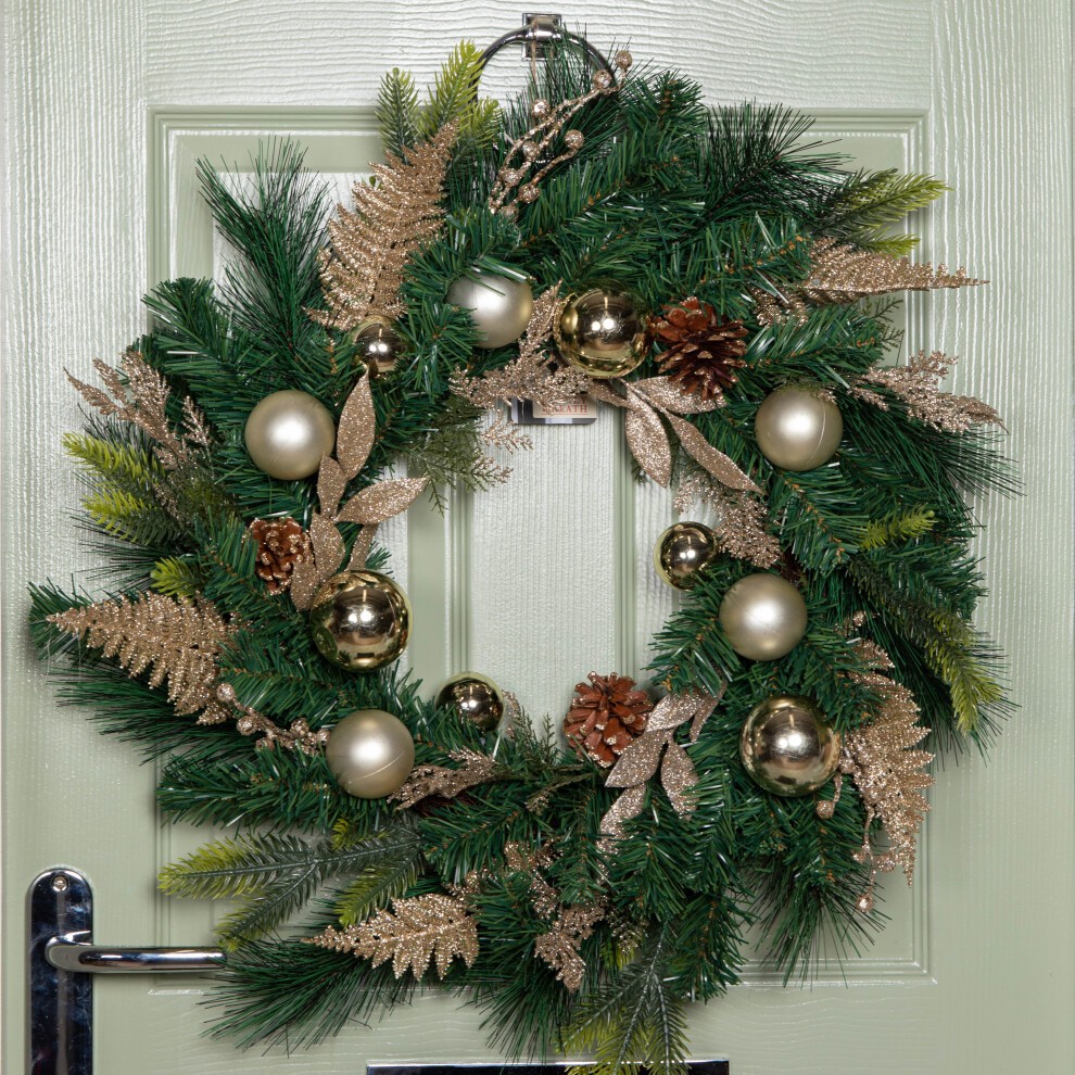 A 60cm green Christmas wreath adorned with gold baubles, glitter berries, and pinecones, featuring metallic accents and lush foliage, hanging on a light green door.