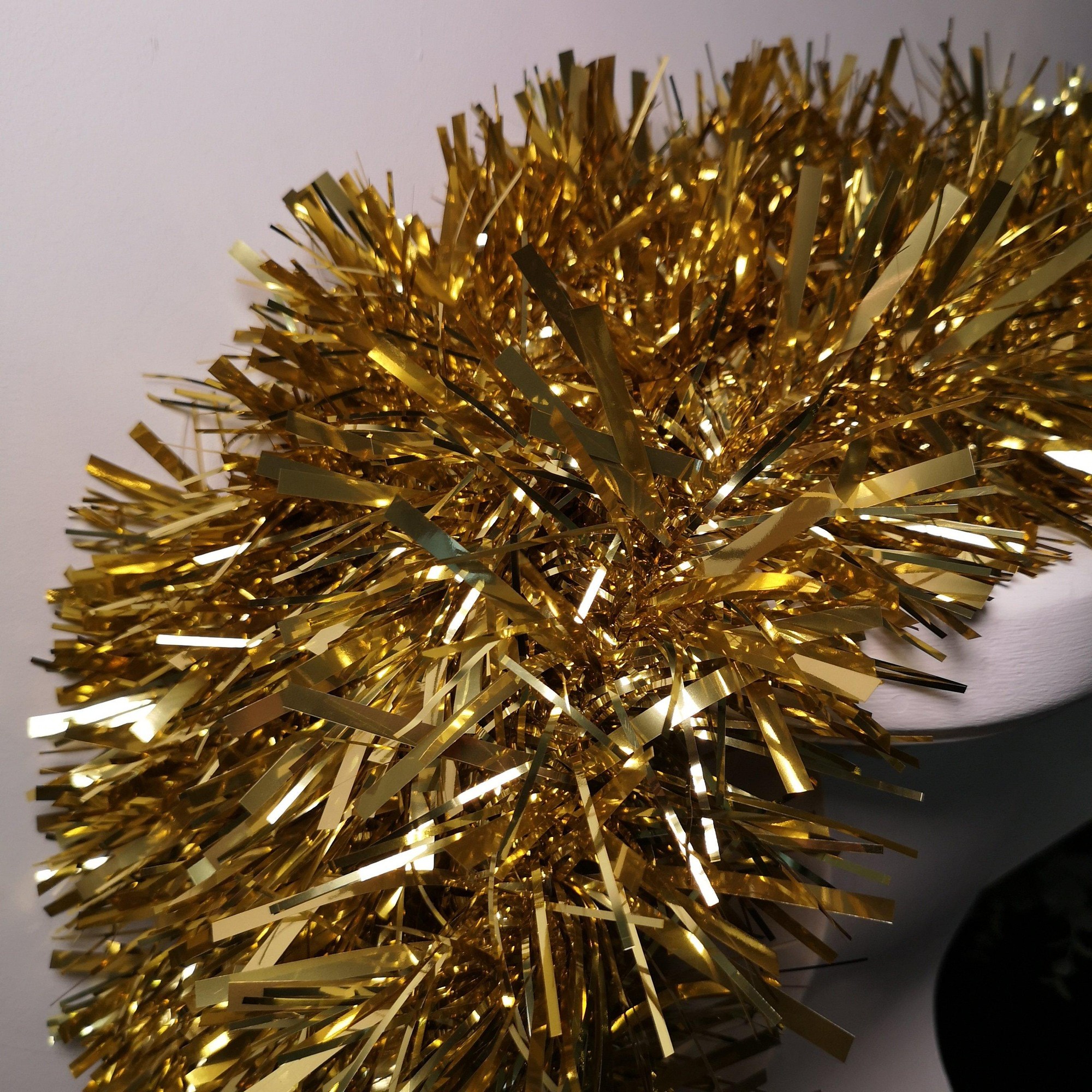 Luxury chunky cut tinsel garland in shiny gold, measuring 10M (33Ft) x 15Cm, featuring long, reflective strands ideal for Christmas tree decoration.