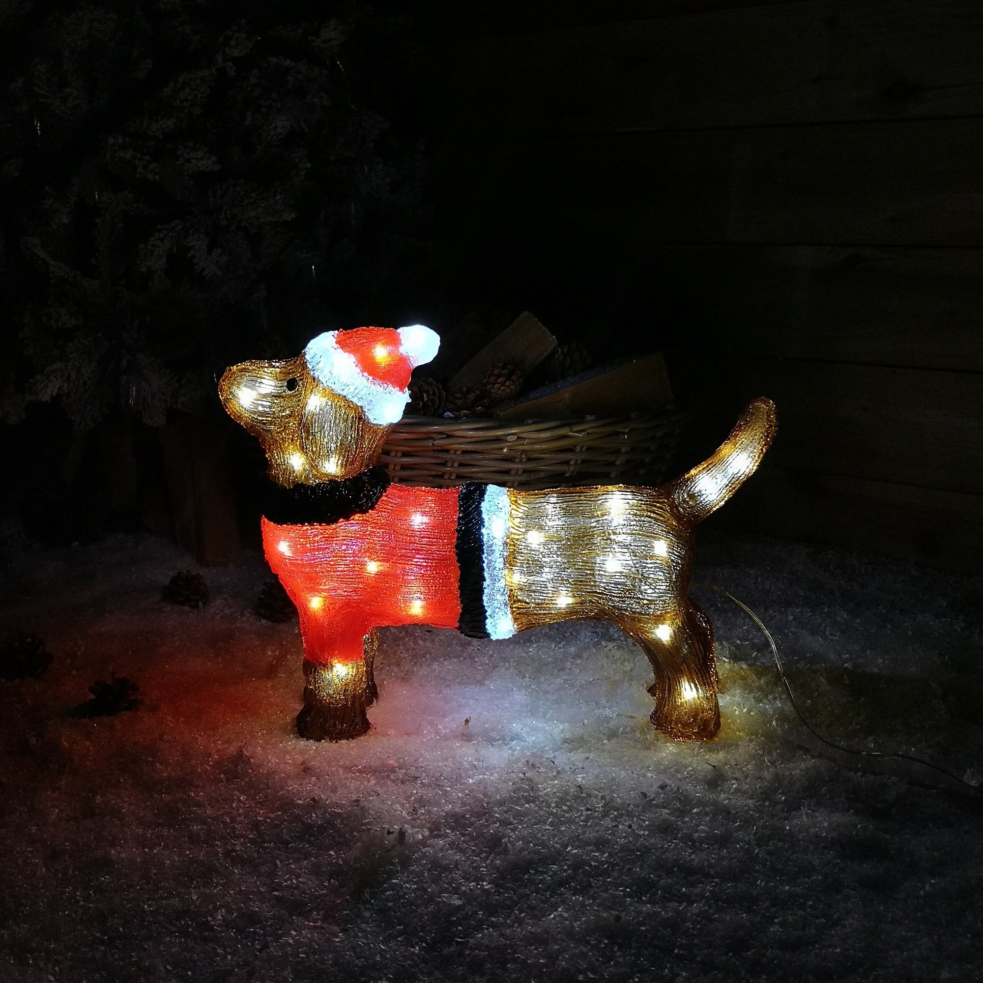 A 36cm acrylic dachshund Christmas decoration featuring 48 ice white LEDs, with a red and black sweater and a Santa hat, set against a snowy background.