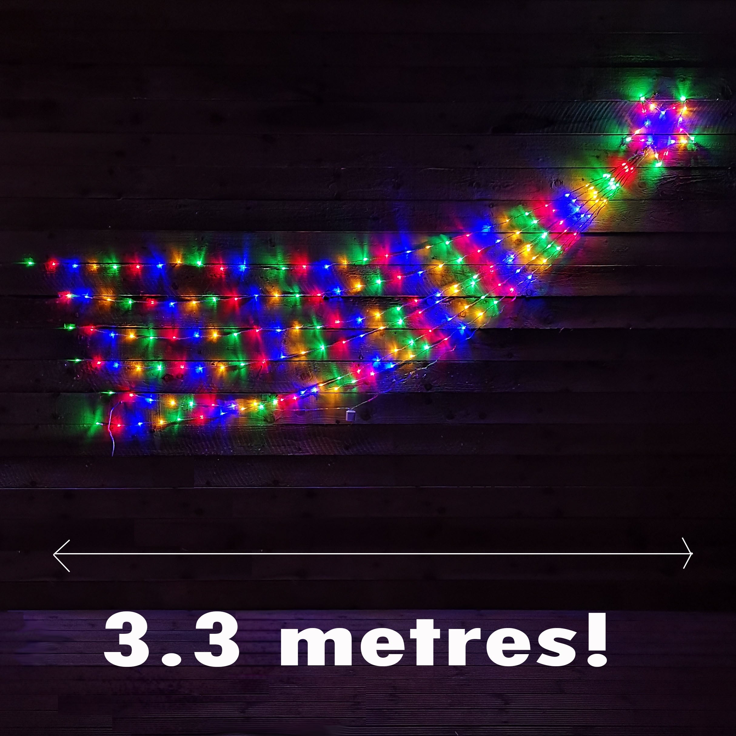 Multicoloured LED Christmas lights in a shooting star silhouette, measuring 3.3 meters, featuring vibrant blue, red, green, and yellow bulbs on a dark wooden background.