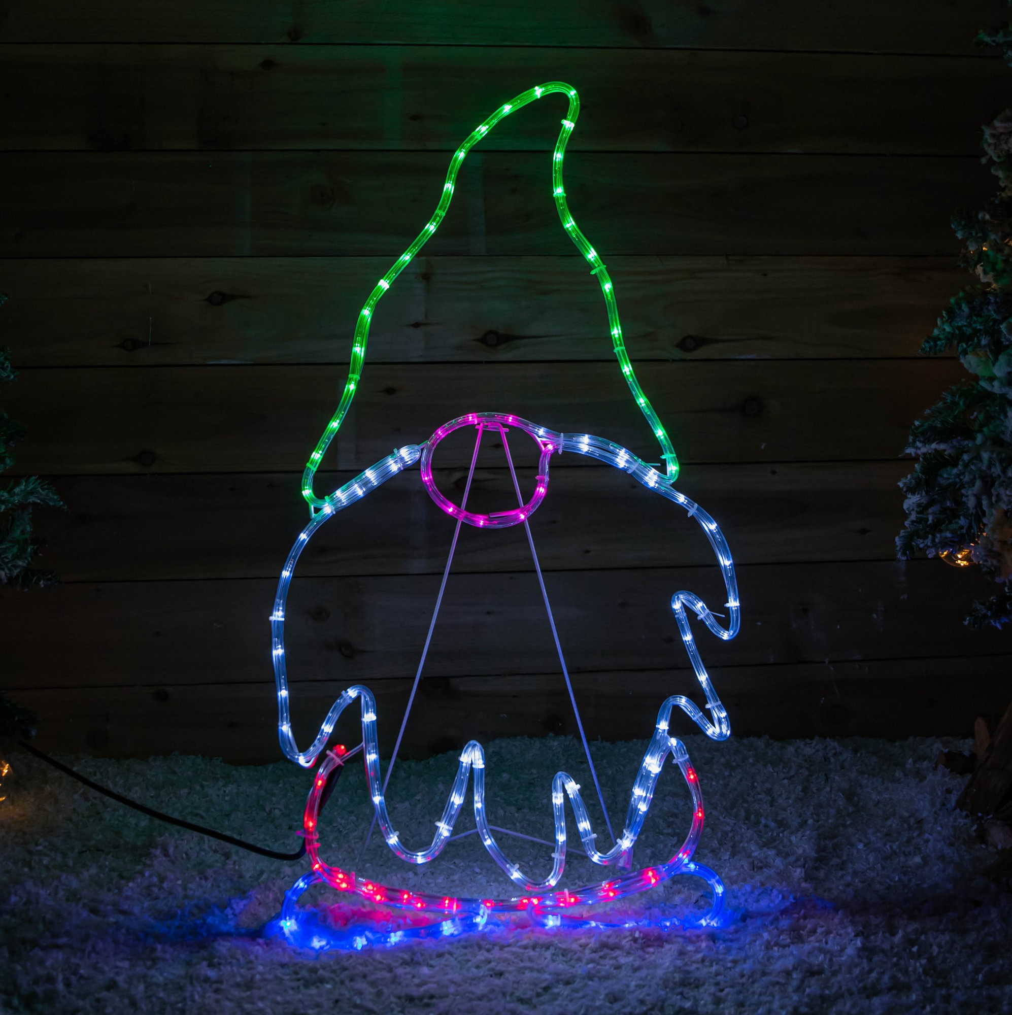 91cm standing Christmas gnome made of flexible rope lights featuring a green hat, pink nose, and multi-coloured LEDs in static and flashing modes, set against a wooden background.