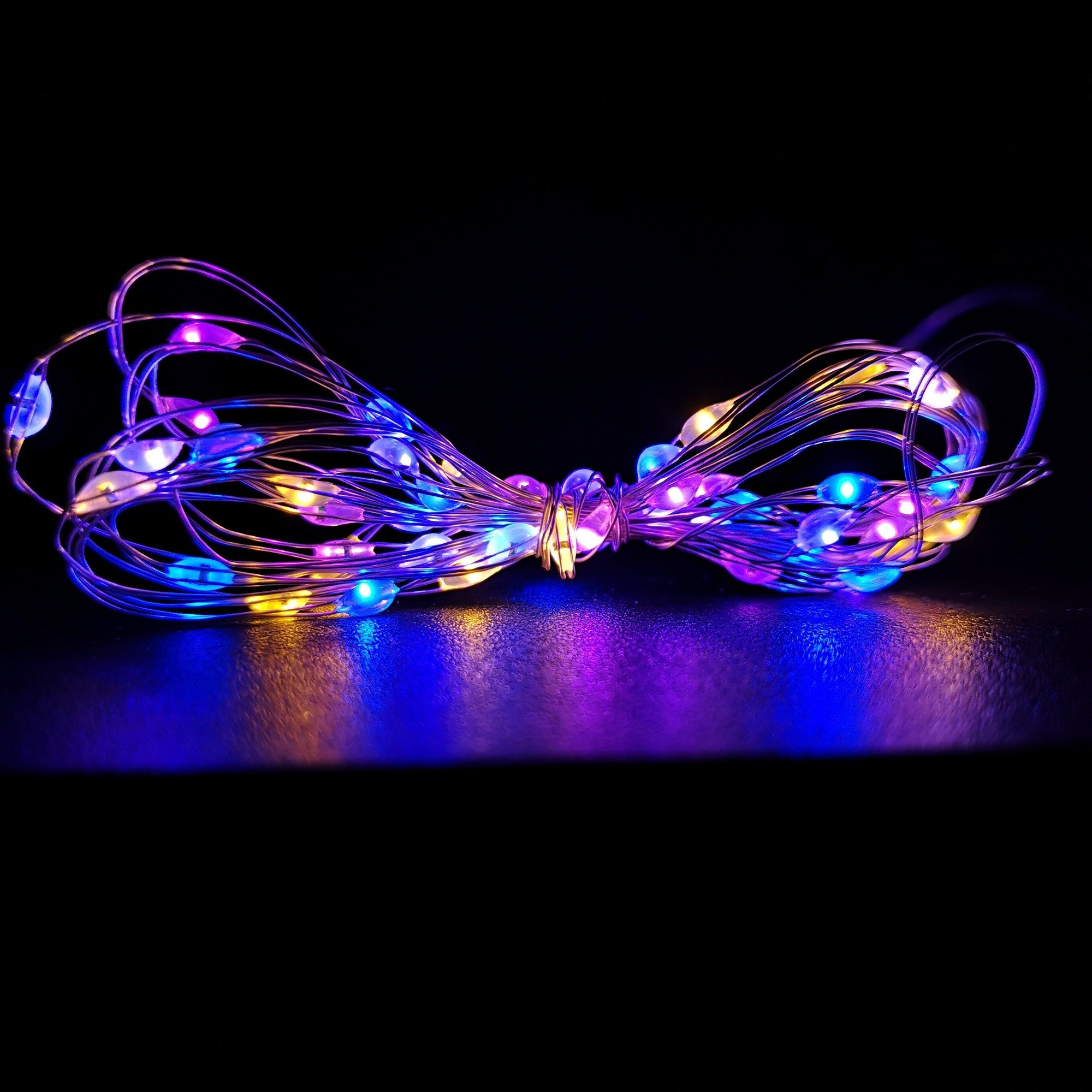 200 LED multi-function battery-operated Christmas lights on a flexible pin wire, featuring vibrant rainbow colors of blue, purple, and yellow, suitable for indoor and outdoor use.