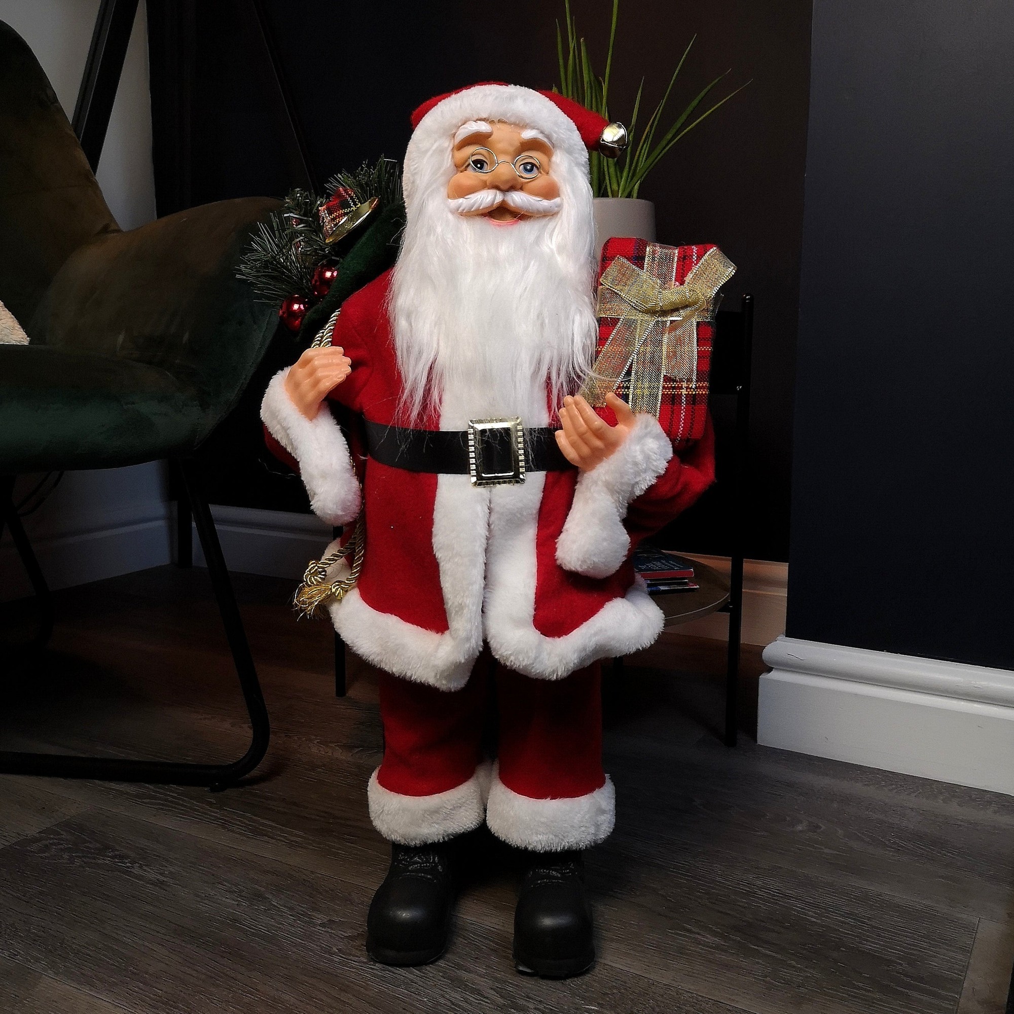 60cm tall red Santa Claus decoration with a fluffy white beard, black boots, holding a present and a green sack, dressed in a red suit with white trim.