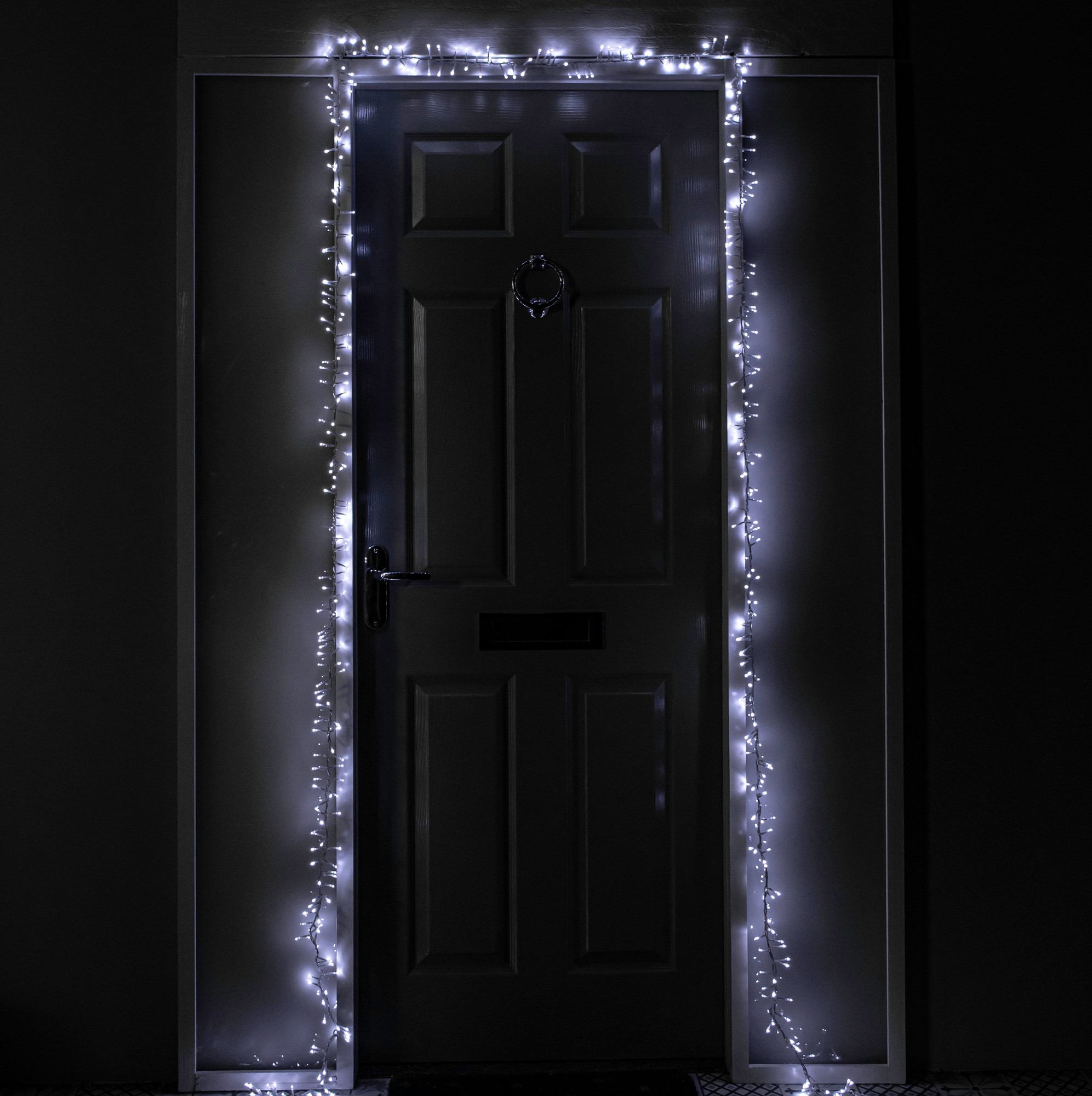 5.5m string lights featuring 440 white LED bulbs, elegantly illuminating a dark door frame, with a timer function for festive decoration.