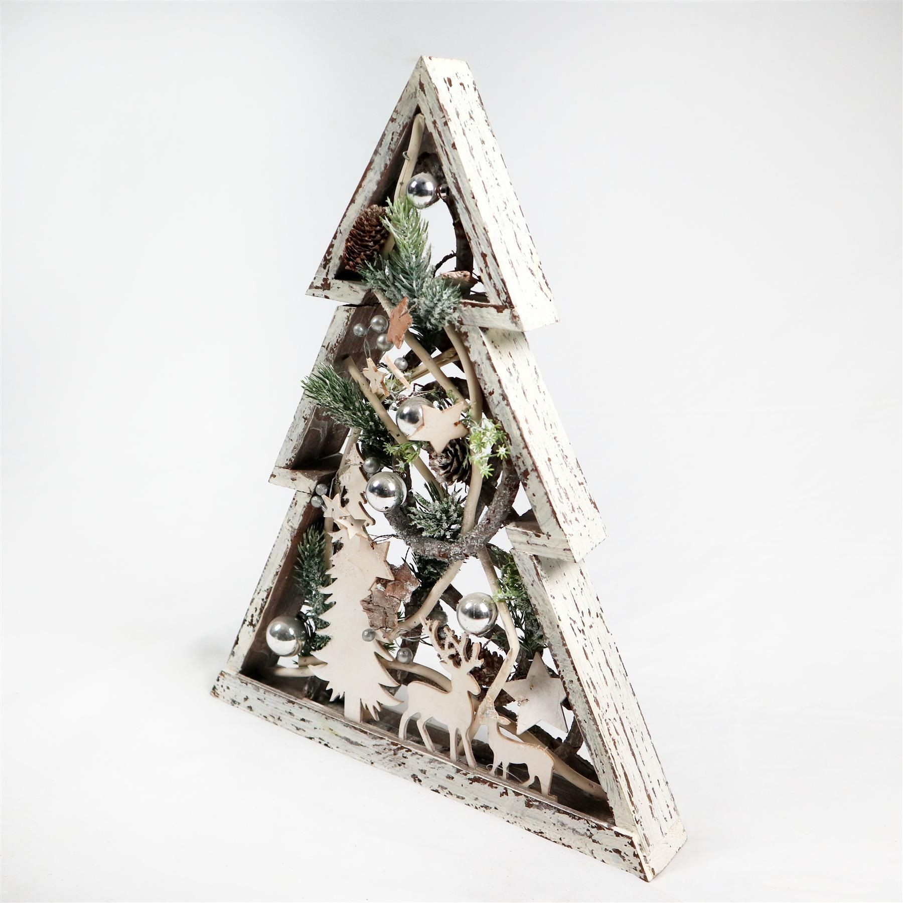 Christmas centerpiece decoration in a wooden tree shape, featuring warm white LED lights, pinecones, silver baubles, and intricate cut-out designs of trees and deer.