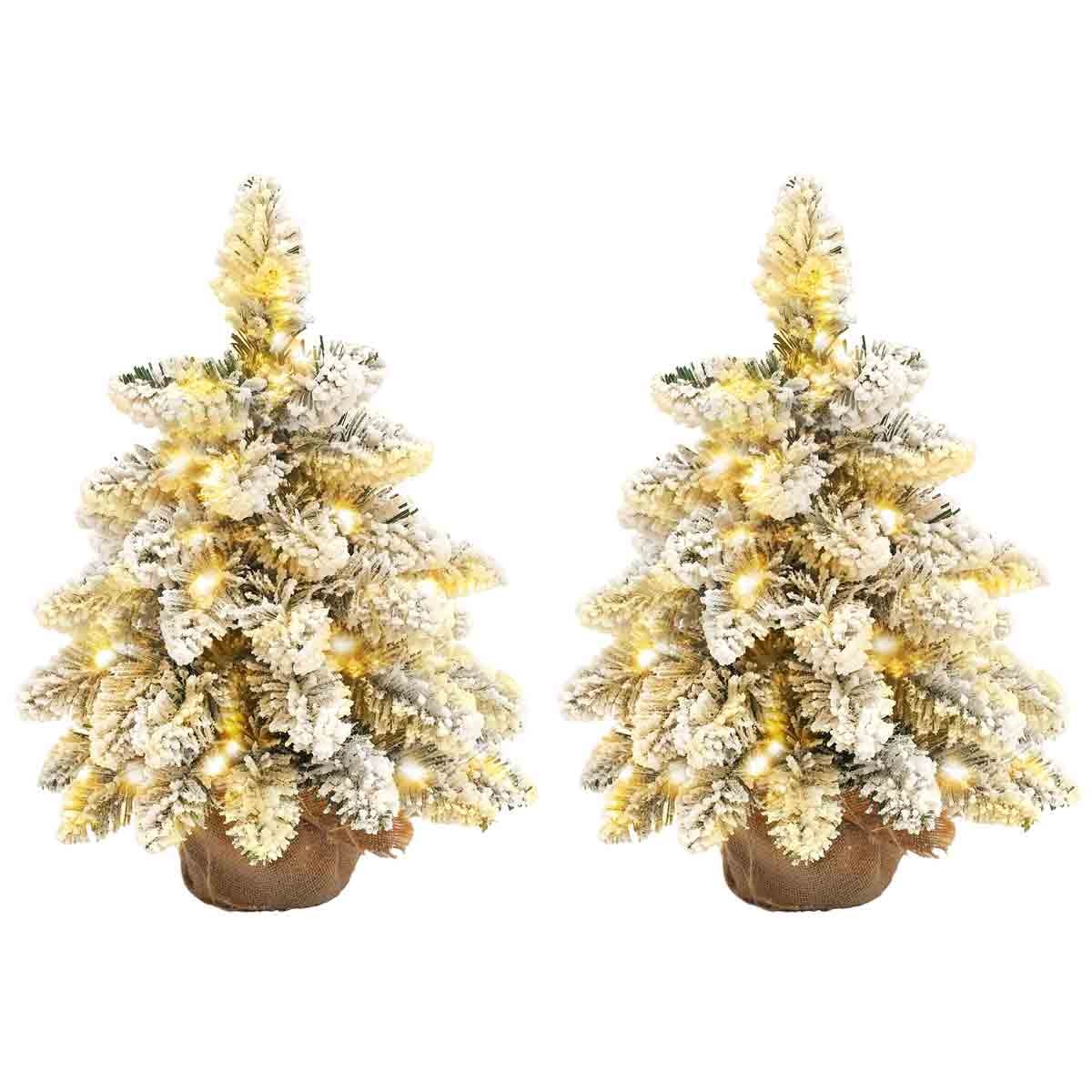 Two mini artificial Christmas trees with flocked white tips, green foliage, and warm white lights, set in brown burlap pots, perfect for tabletop holiday decor.