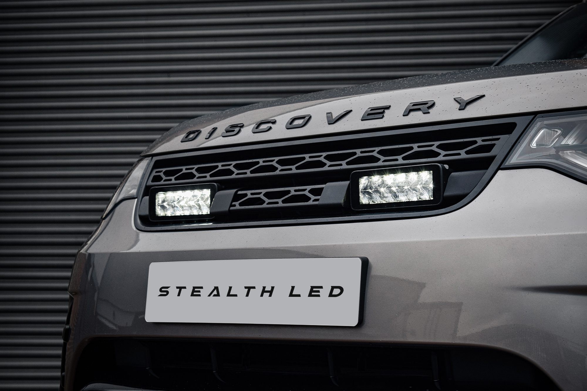 Stealth LED integration kit for Land Rover Discovery 5, featuring twin 7" luminous LED lights, sleek black housing, and a silver vehicle front with "DISCOVERY" branding.