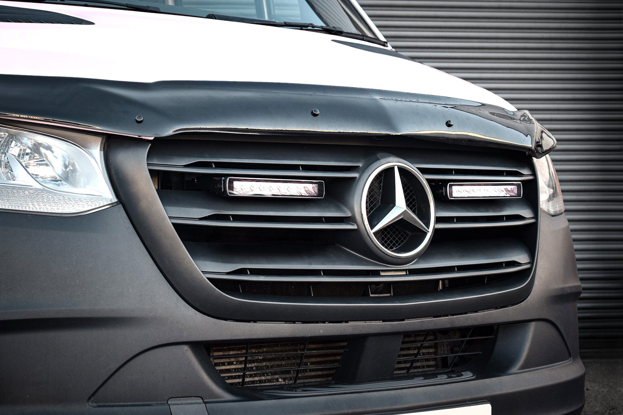 Black grille kit for a 2019+ Mercedes Sprinter, featuring twin 10" luminous LED lights, sleek design, and the iconic Mercedes emblem prominently displayed.
