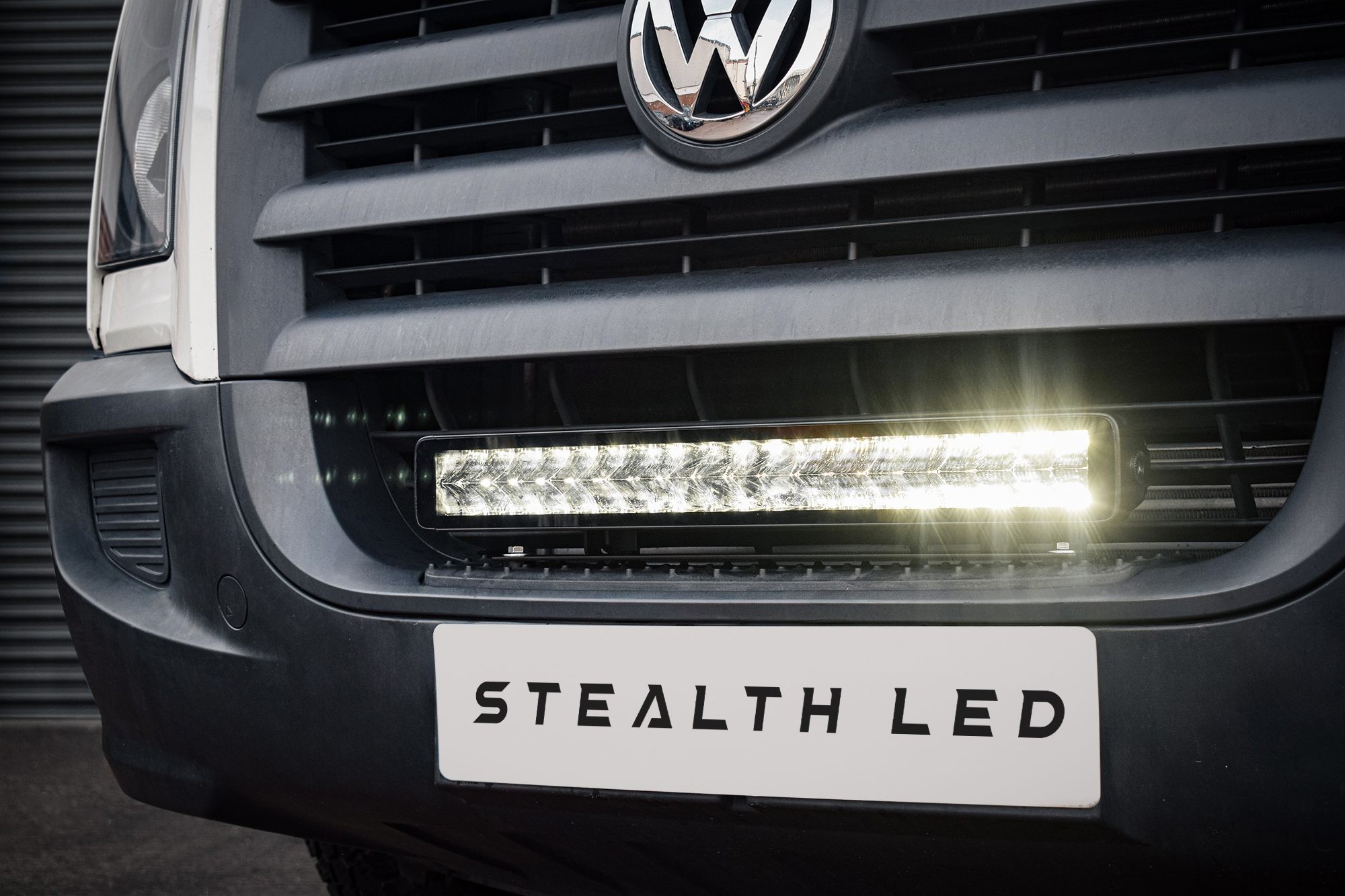 Luminous LED integration grille kit for VW Crafter 2006-2011, featuring a sleek black grille, chrome VW emblem, and bright 21" LED light bar with 16,800 lumens output.