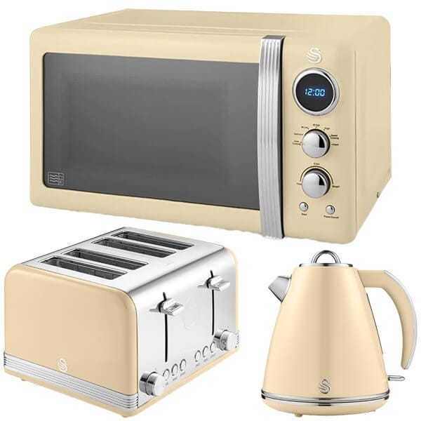 Cream-colored retro kettle, four-slice toaster with chrome accents, and a digital microwave with a sleek design and blue display, all by Swan.