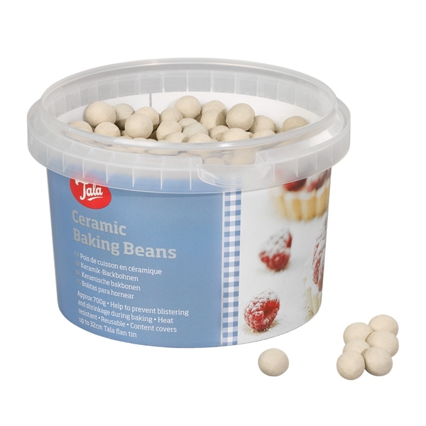 White ceramic baking beans in a clear plastic container with a blue label, featuring the Tala logo and baking instructions, with a few beans scattered outside the tub.