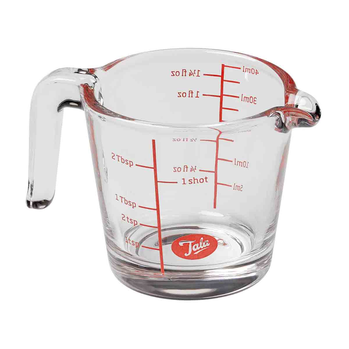 Clear glass measuring jug with a spout, featuring red measurement markings for milliliters and ounces, and a red Tala logo on the base.