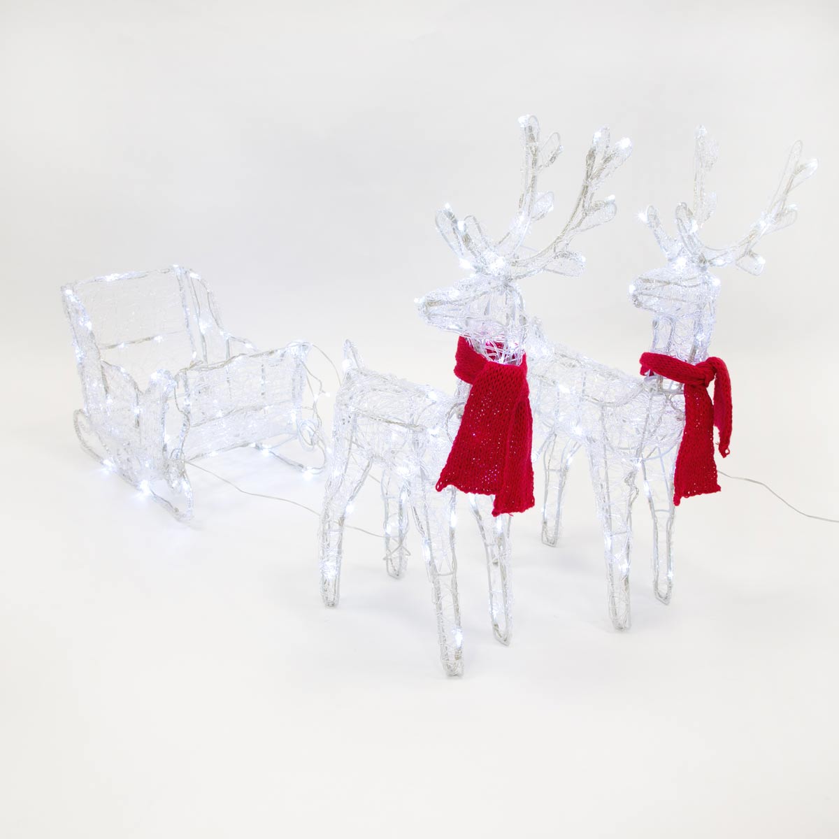 Two illuminated acrylic reindeer with antlers and red scarves stand beside a matching sleigh, all adorned with 150 LED lights, creating a festive holiday display.
