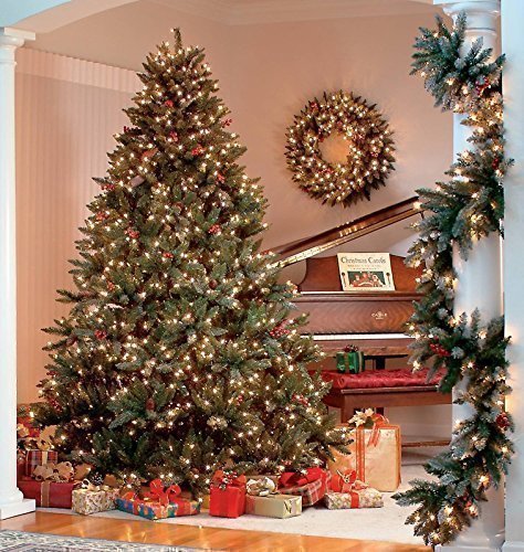 A 7ft frosted pre-lit Christmas tree adorned with red berries and warm white lights, surrounded by wrapped gifts, set in a cozy holiday-themed room.