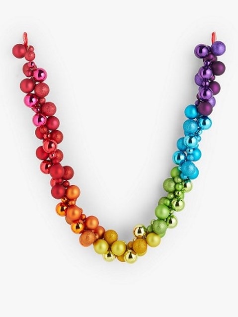 Colorful garland featuring shiny baubles in a rainbow gradient, with red, orange, yellow, green, blue, and purple hues, made of glossy material and strung together with a red ribbon.