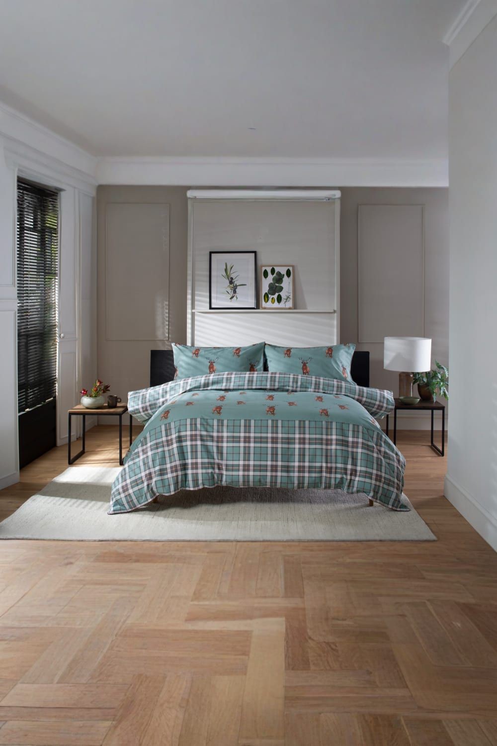 Highland Fell 100% cotton duvet cover set in green with stag print, featuring a plaid design, styled on a bed with matching pillows in a modern bedroom setting.