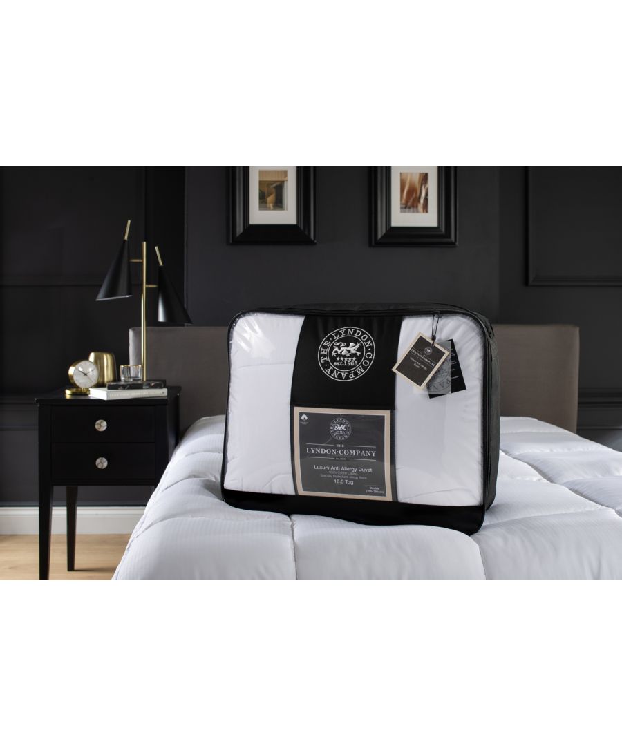 Luxury anti-allergy soft touch duvet in white, 10.5 tog, single size, packaged with a black and white label, displayed on a bed with a dark wall and bedside lamp.