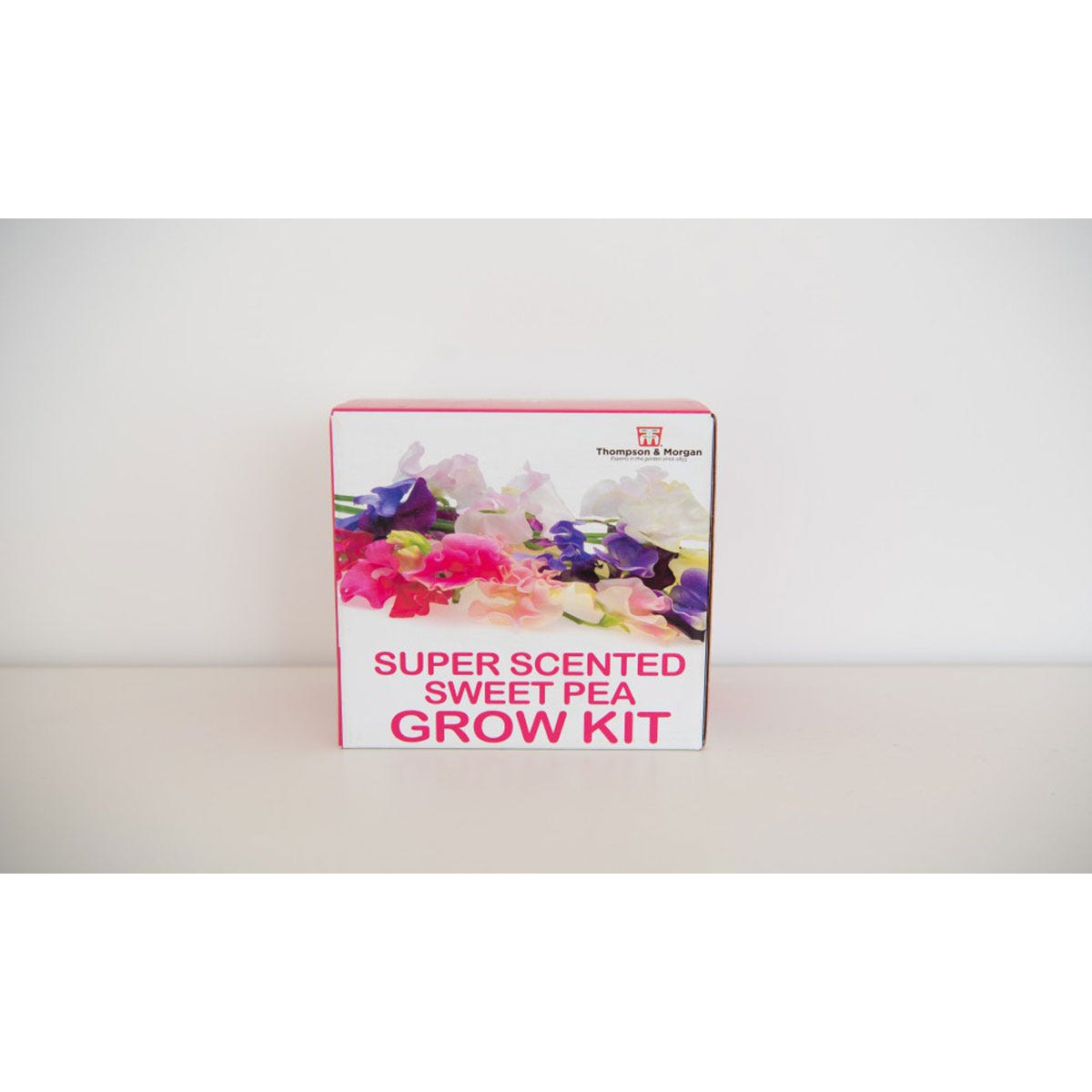 Brightly colored box featuring a floral design, labeled "Super Scented Sweet Pea Grow Kit," containing five varieties of sweet pea seeds in finished foils.