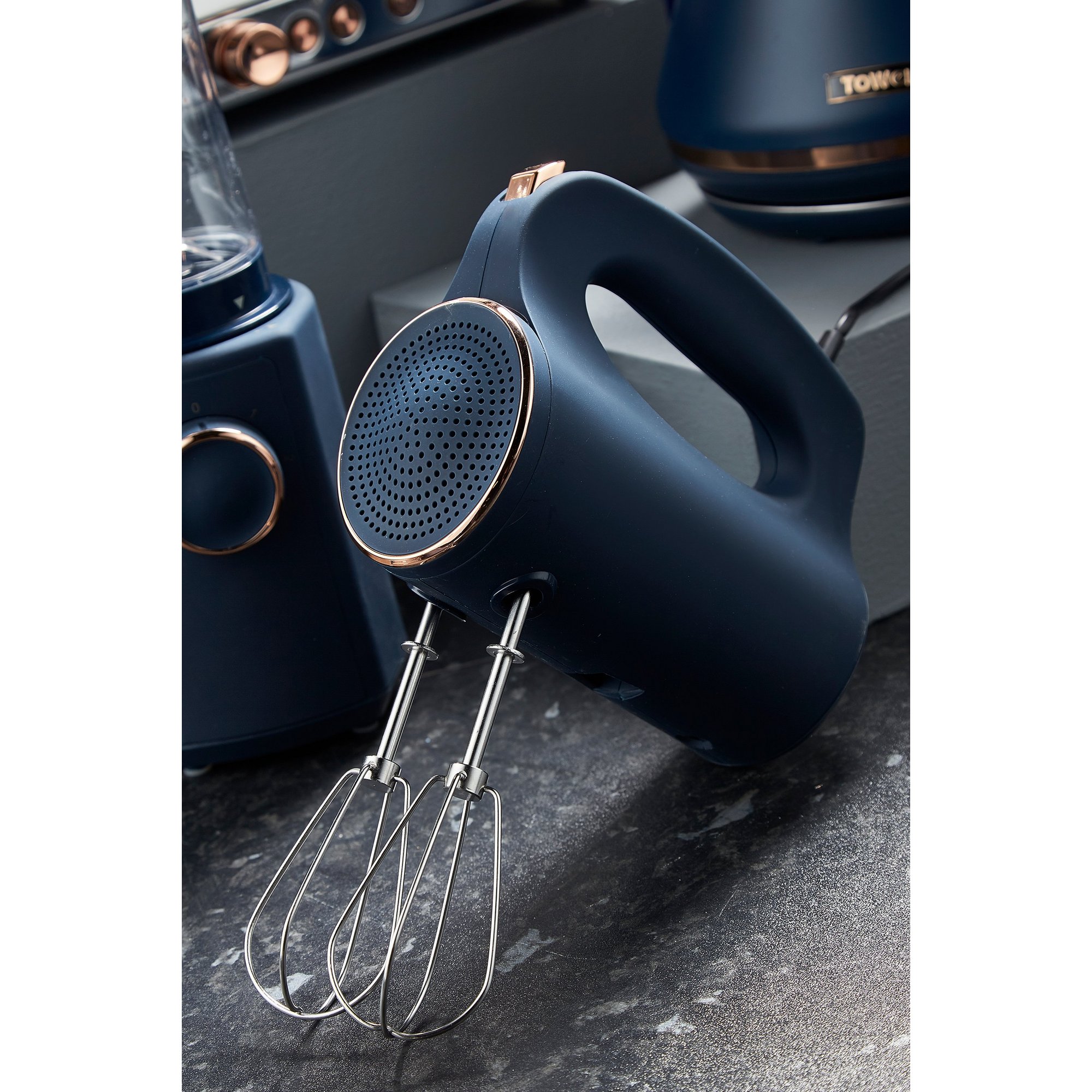 Midnight blue Tower Cavaletto hand mixer features a sleek design with a textured grip, stainless steel beaters, and stylish rose gold accents.