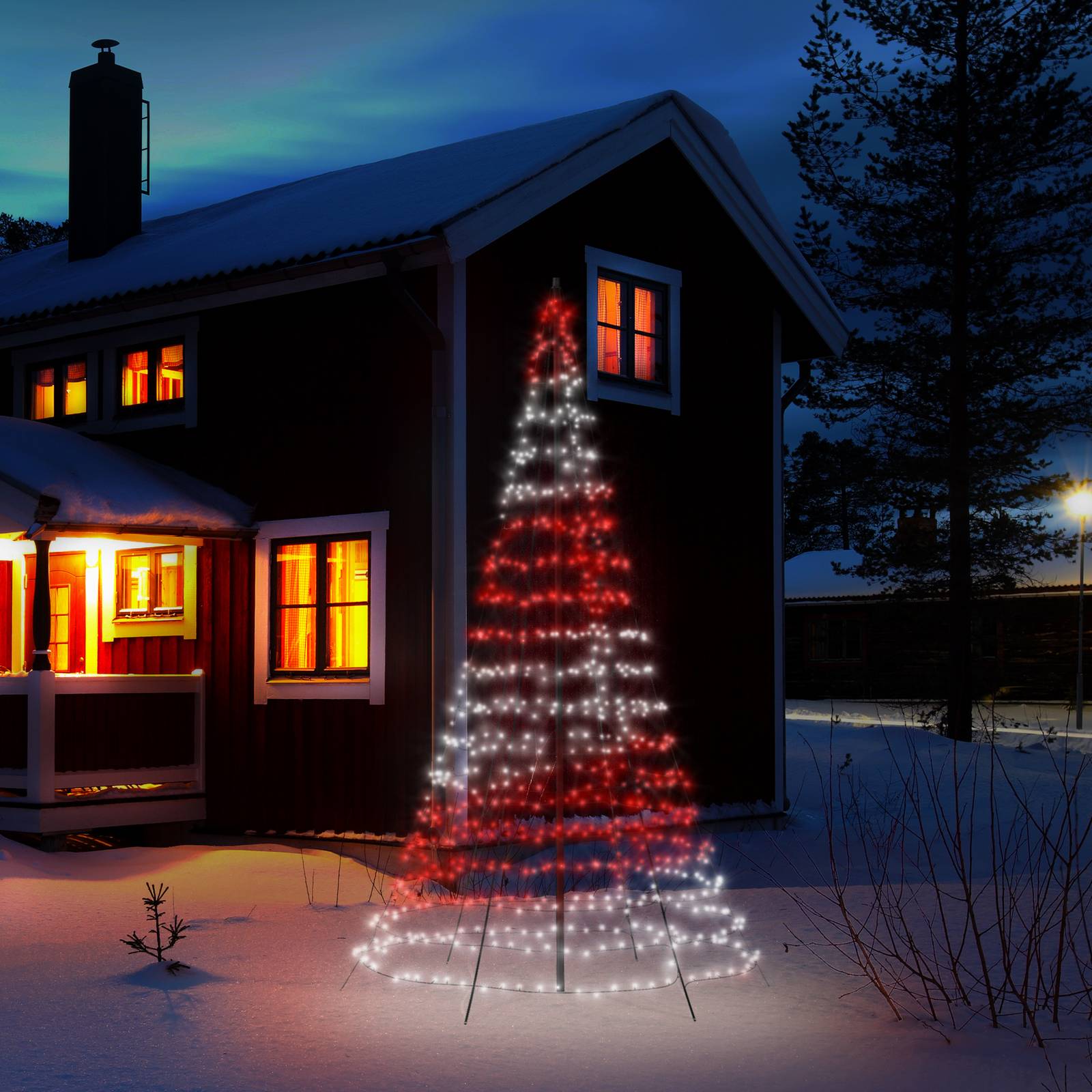 A colorful outdoor Christmas tree made of LED lights, featuring red and white twinkling lights, set against a snowy landscape near a cozy, warmly lit cabin.