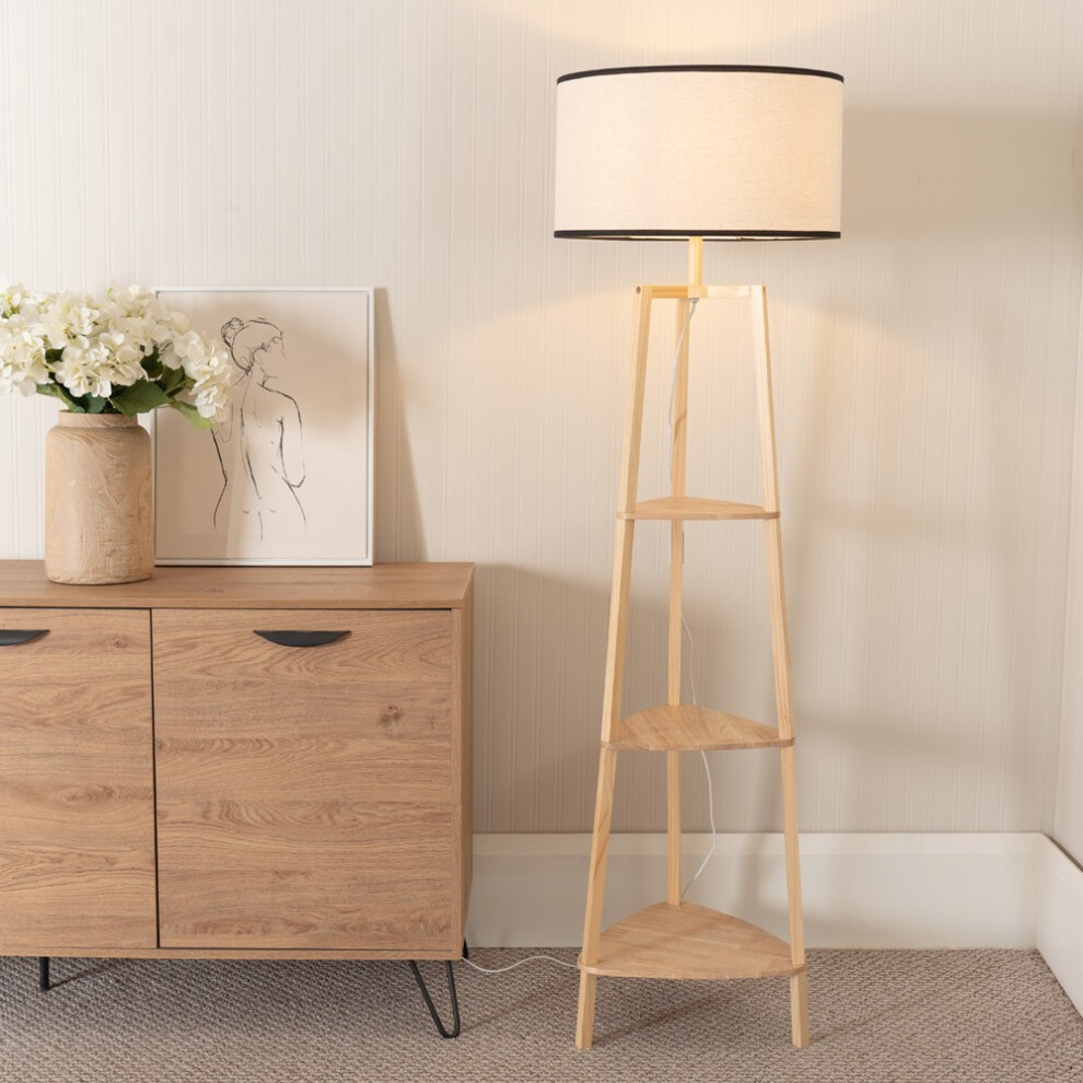 Wooden 3-tier shelf floor lamp in black with a trimmed linen shade, featuring a natural wood finish and a minimalist design, placed next to a modern cabinet and artwork.