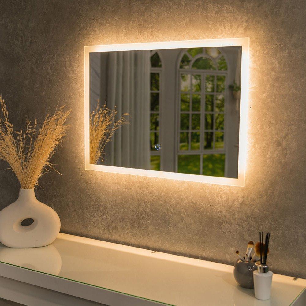 Backlit LED bathroom mirror in silver, measuring 50 x 70cm, features a touch control demister and a sleek, modern design against a textured gray wall.
