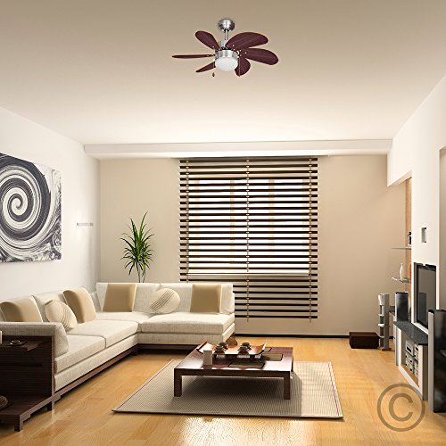 Chrome and black ceiling fan with six blades, featuring a sleek silver finish and a central light, set in a modern living room with a beige color scheme and wooden flooring.