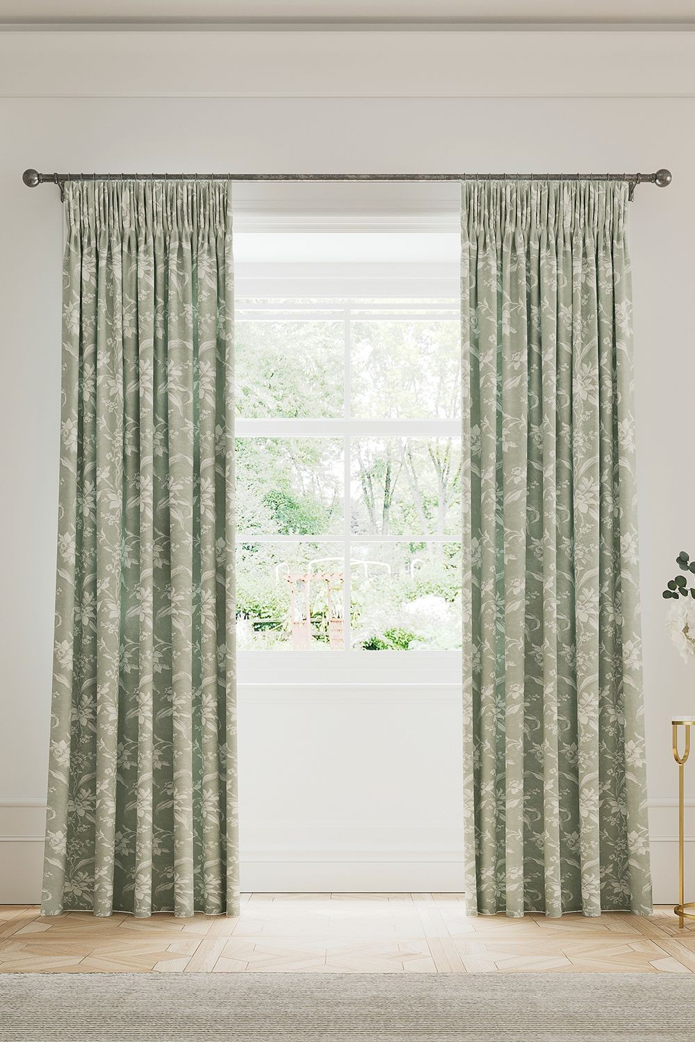 Soft green cotton-lined curtains featuring a delicate daffodil pattern, elegantly gathered at the top, framing a bright window with a view of greenery outside.