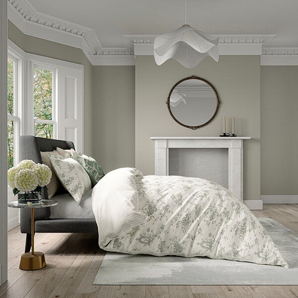 Cotton duvet cover set featuring a delicate floral design in soft greens and whites, paired with matching pillowcases, set against a stylish, modern bedroom backdrop.
